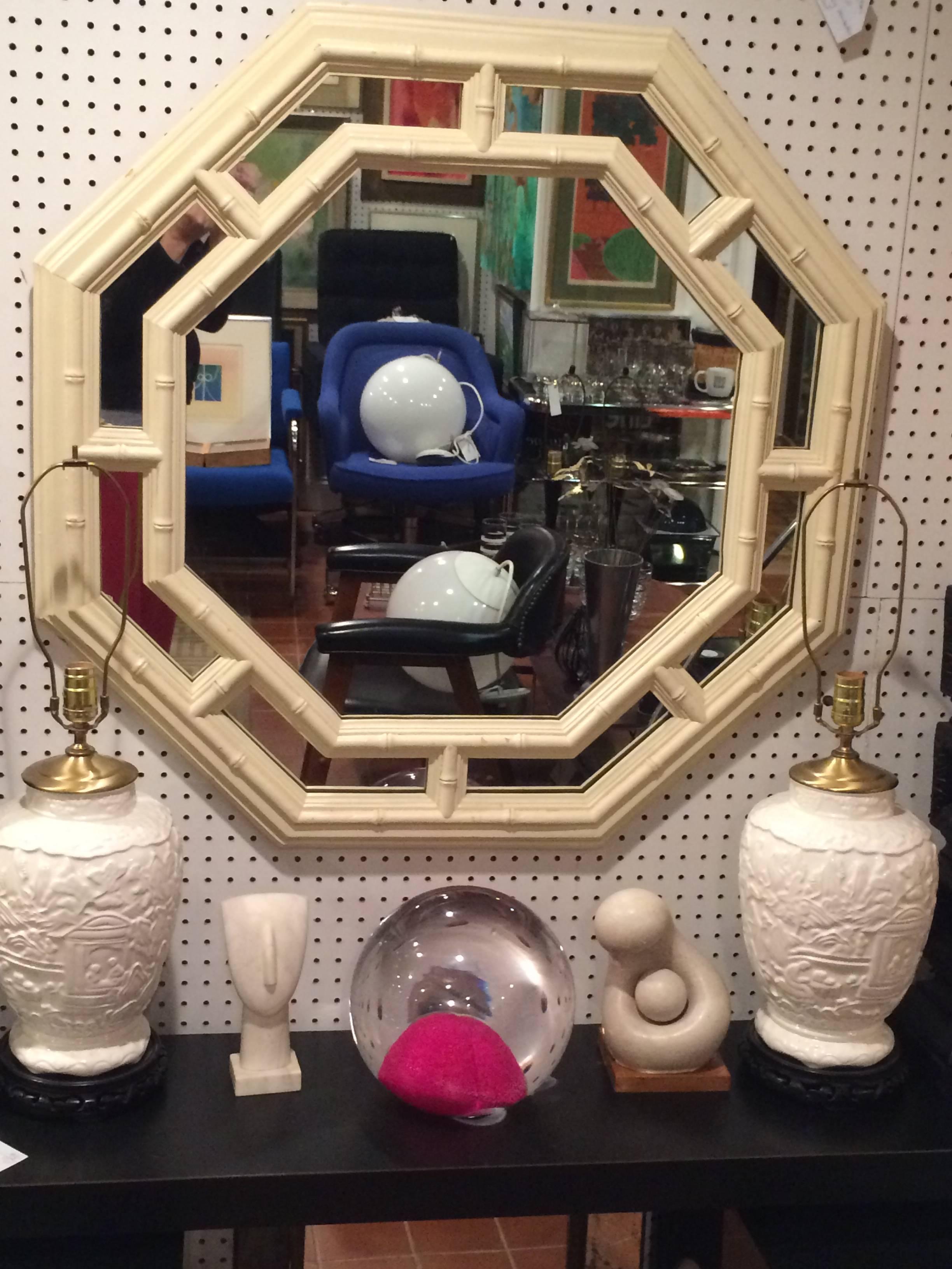Faux bamboo Hollywood Regency octagonal mirror in crème or off-white. Heavy composition mirror that makes a real statement. Can be painted any color to pop off your walls. Please see second set of photos with mirror off the wall the item was touched