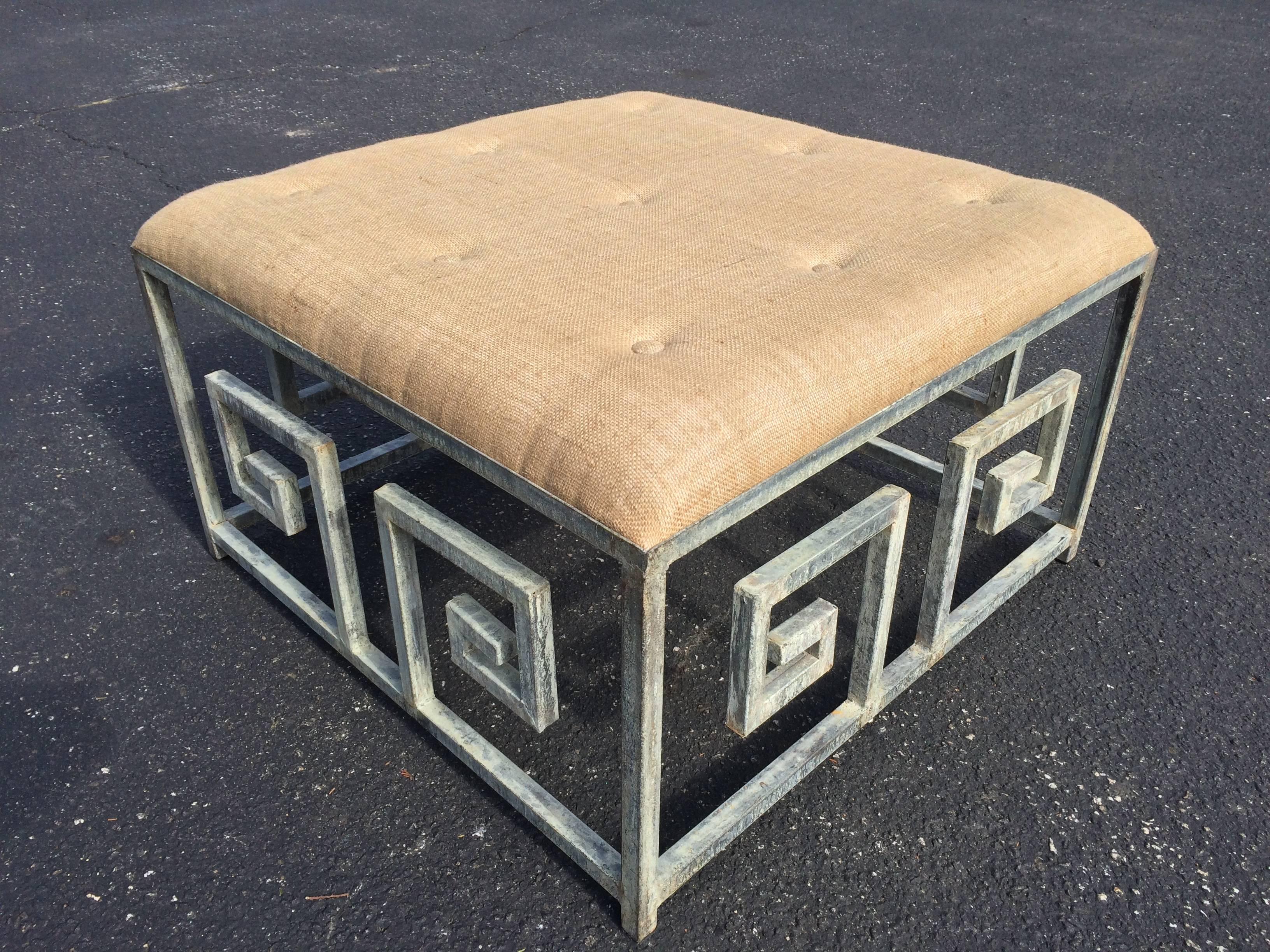 Greek key iron ottoman coffee table with patinated/weathered copper-like finish in Iron. Nice comfortable tufted burlap upholstery top. Casual but sophisticated. Item is new and unused. Only one available.