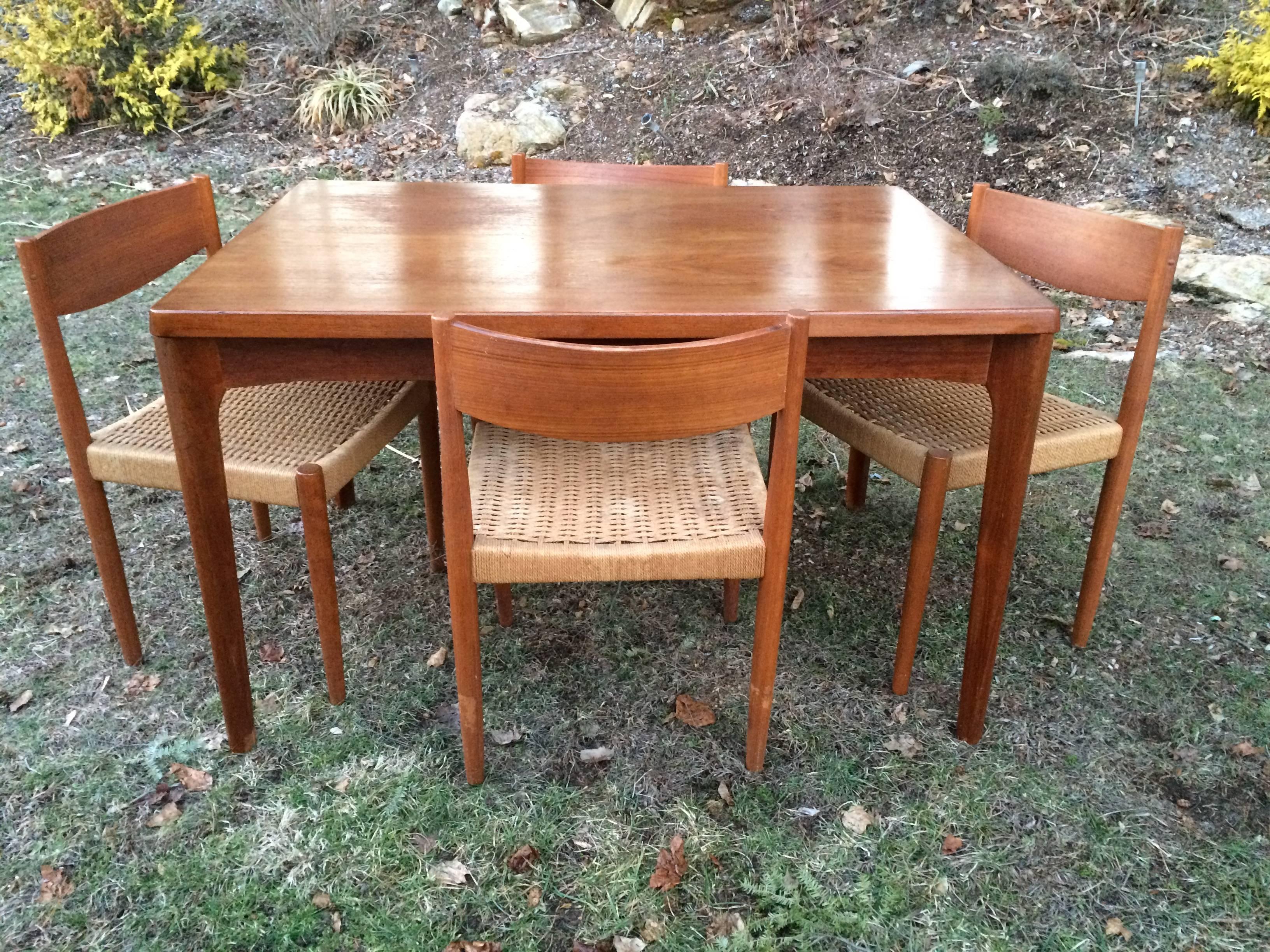 Danish Modern Extendable Teak Dining Table with Woven Chairs. Signed Stole Mobelfabrik. Made in Denmark. The table has been refinished since these photos were taken. The table measures 30 in.H x 84 in. W x 32 in.D when fully extended. Un-extended
