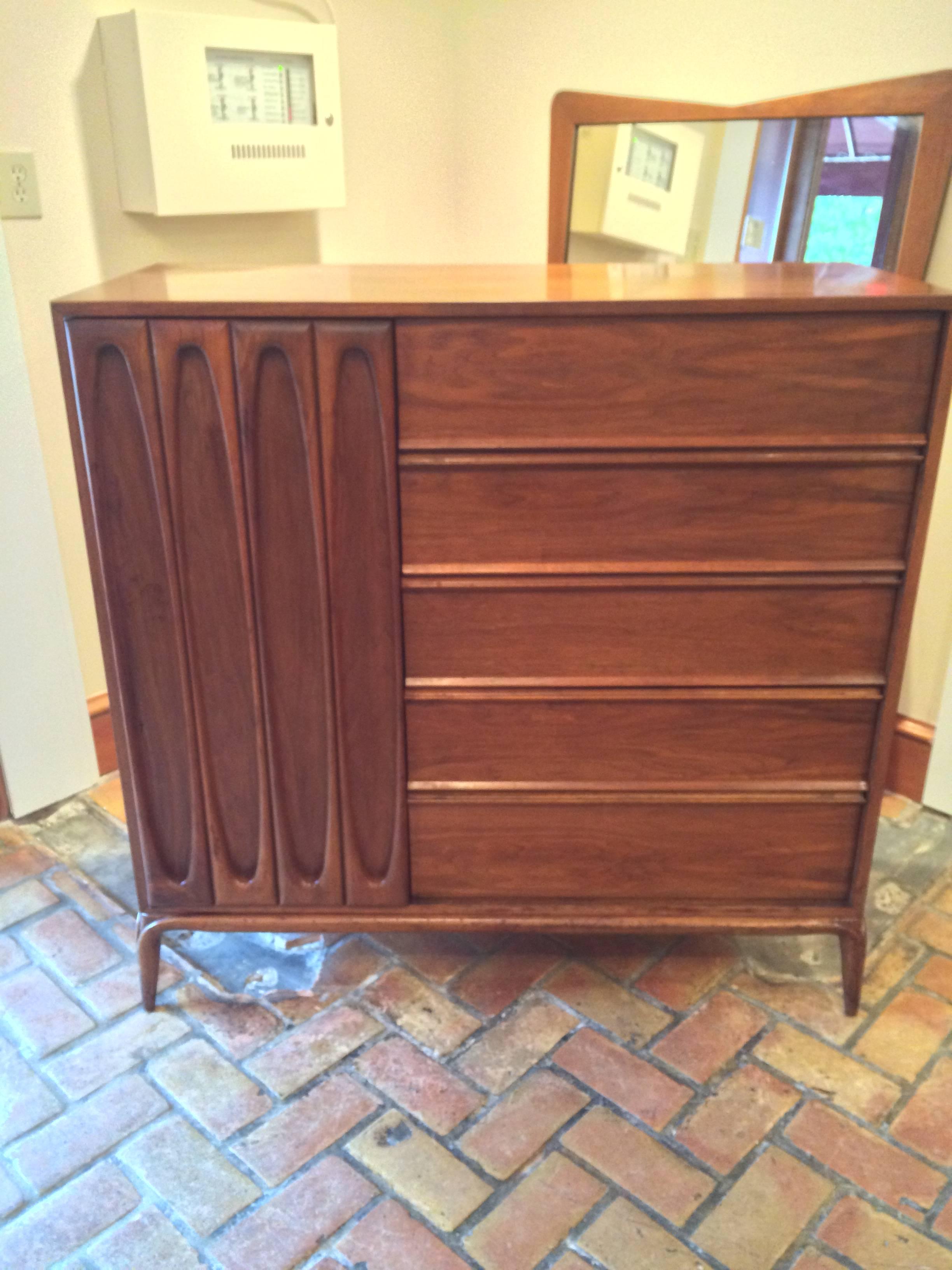 Sculptural Mid-Century Modern highboy dresser.Fabulous storage piece. This  walnut beauty has 5 deep drawers and a sculptural door on the left that opens to 5 smaller pull out drawers. Matching nightstands and credenza available as well. Matching