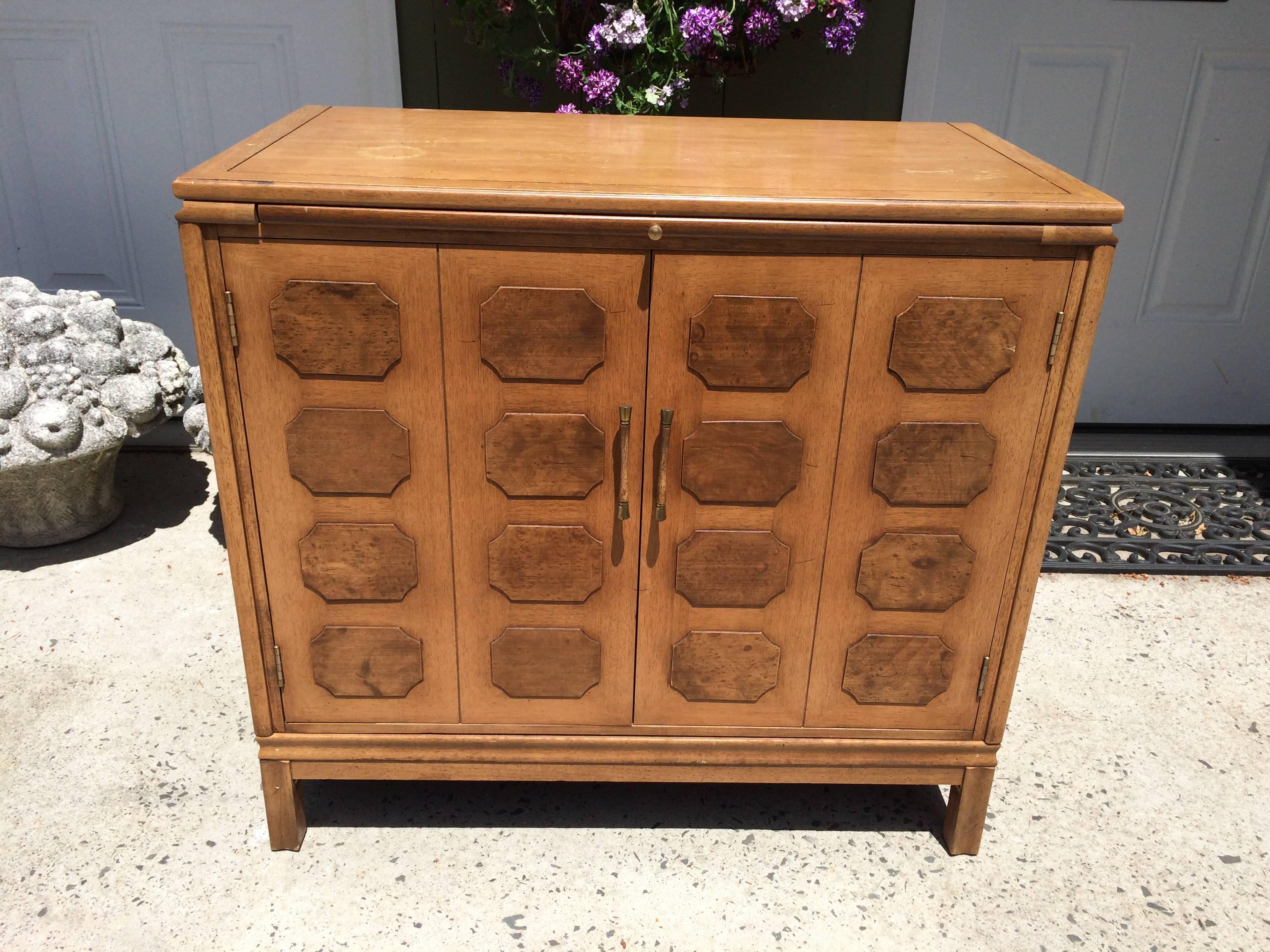 Paneled Mid-Century Bar cabinet Signed Tamerlane by Thomasville. This sophisticated piece  has a black laminate pullout for pouring drinks, two cabinet doors that open to store glasses and liquor and a drawer for corkscrews, bottle openers and other