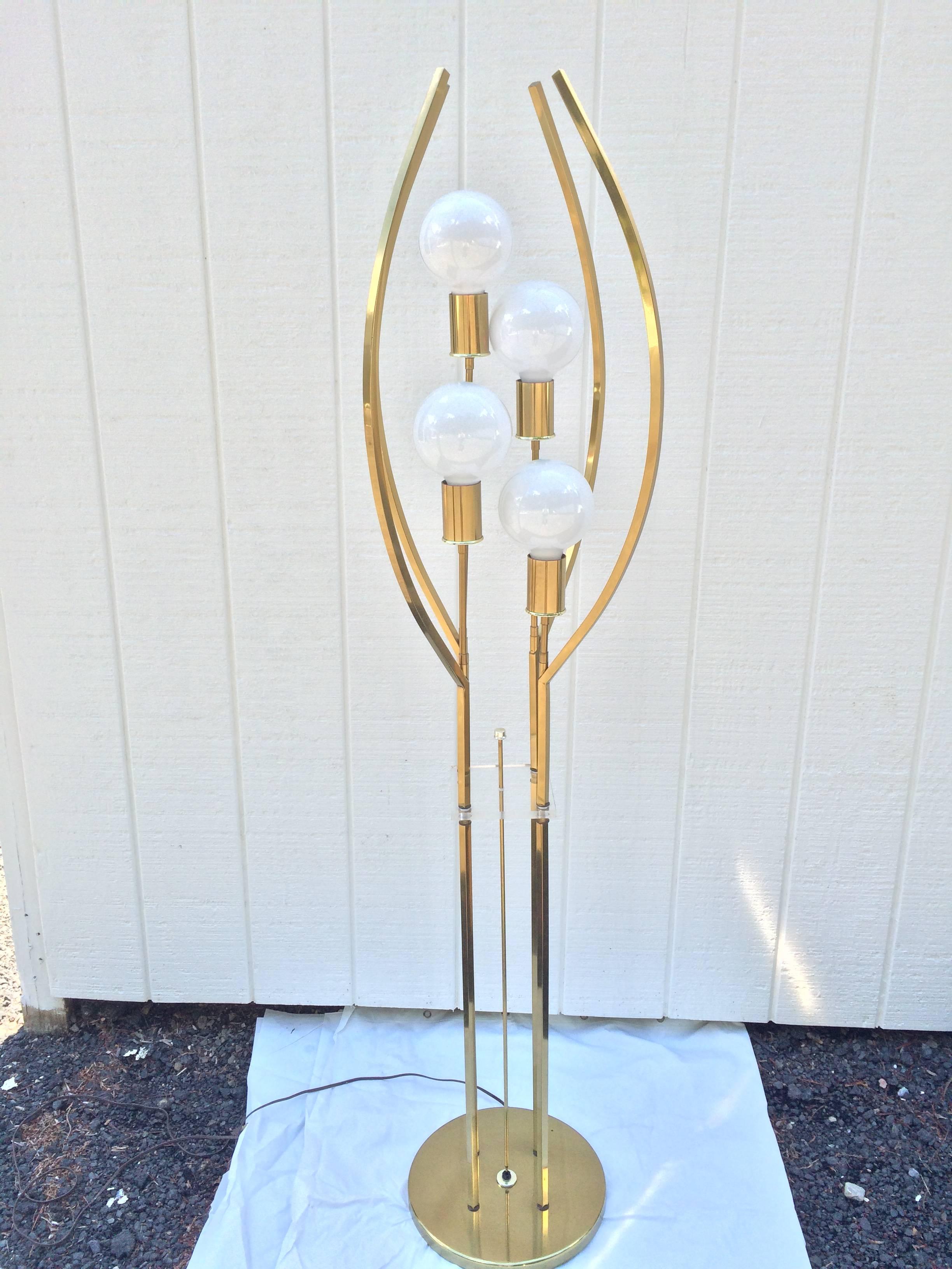 Brass and Lucite floor lamp. Stunning full length beauty with semi-caged four globes waisted with a Lucite shelf with switch. Stunning piece which can light up all four globes or two and two with its three-way switch. Spage Age meets Hollywood Glam.