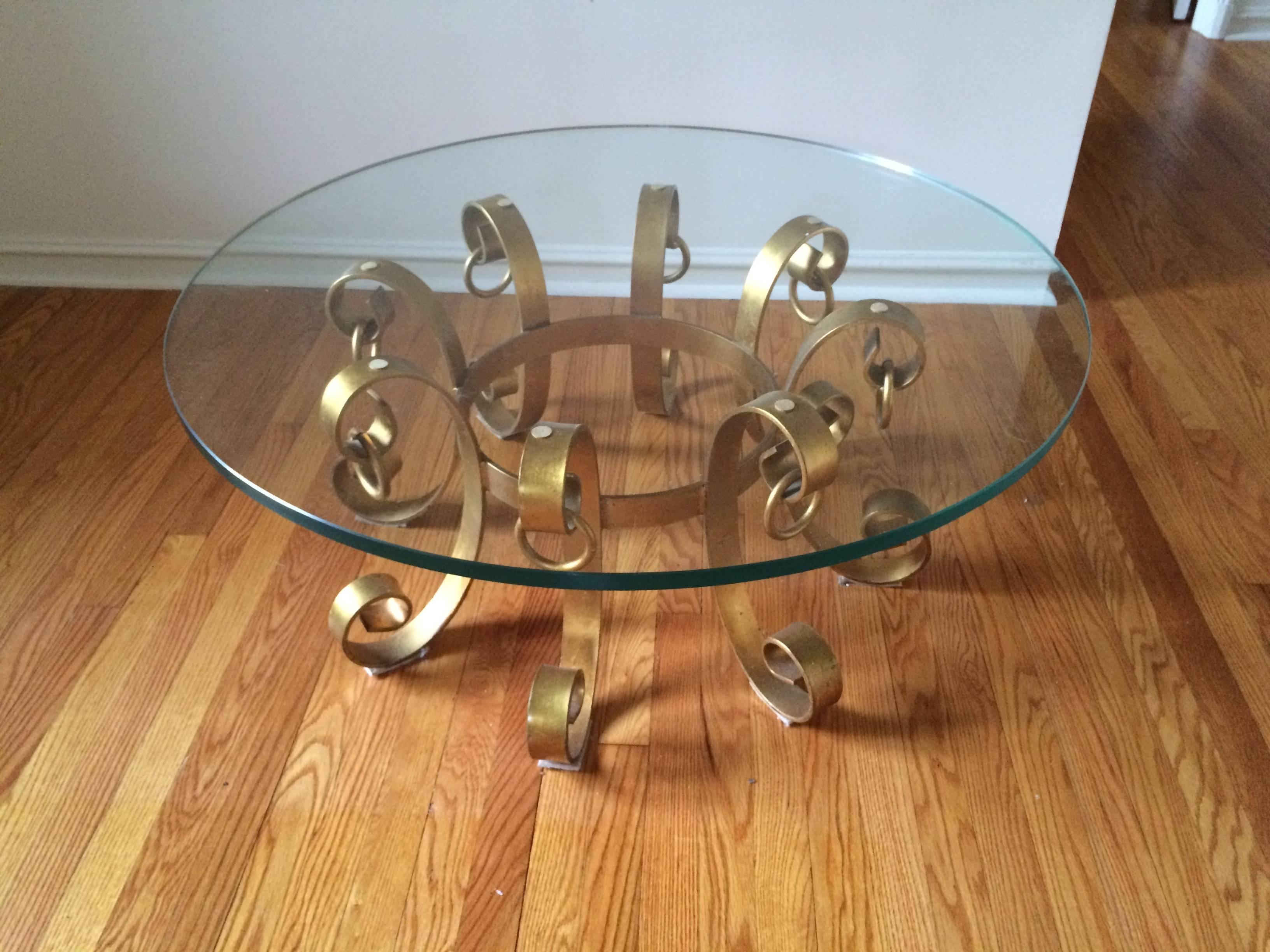 Hollywood Regency gilt iron coffee table. This elegant table boasts heavy iron construction .This is a solid well built piece. We need the floor space so this is a bargain.
Please note that the The original thick glass top in the first two photos is