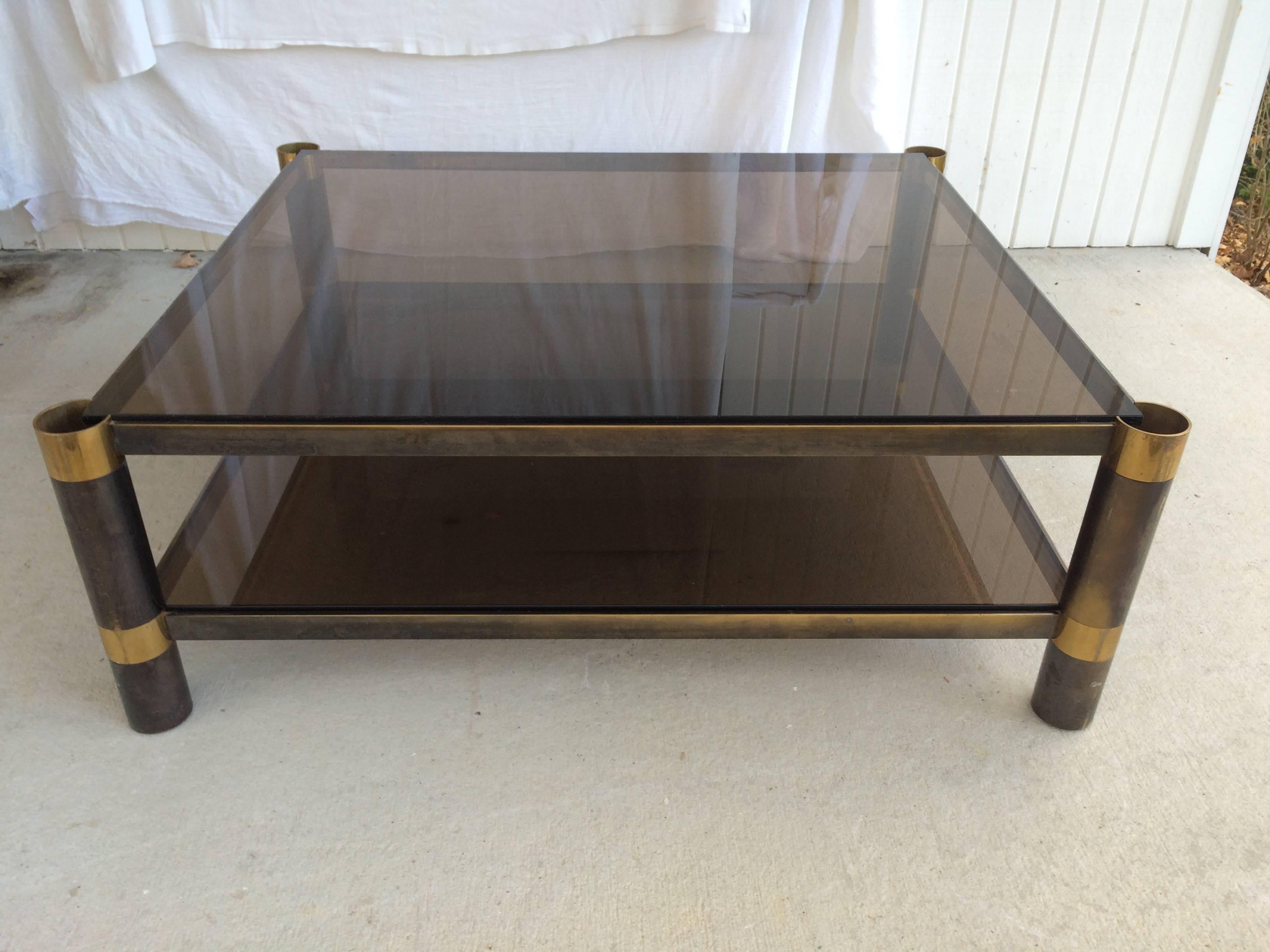 Signed Karl Springer two-tiered smoked glass coffee table. This large nickel and brass coffee table has cylindrical legs and will make a sexy addition to any room. We have had new brass caps for the leg tops fabricated.
Final Markdown. This item is