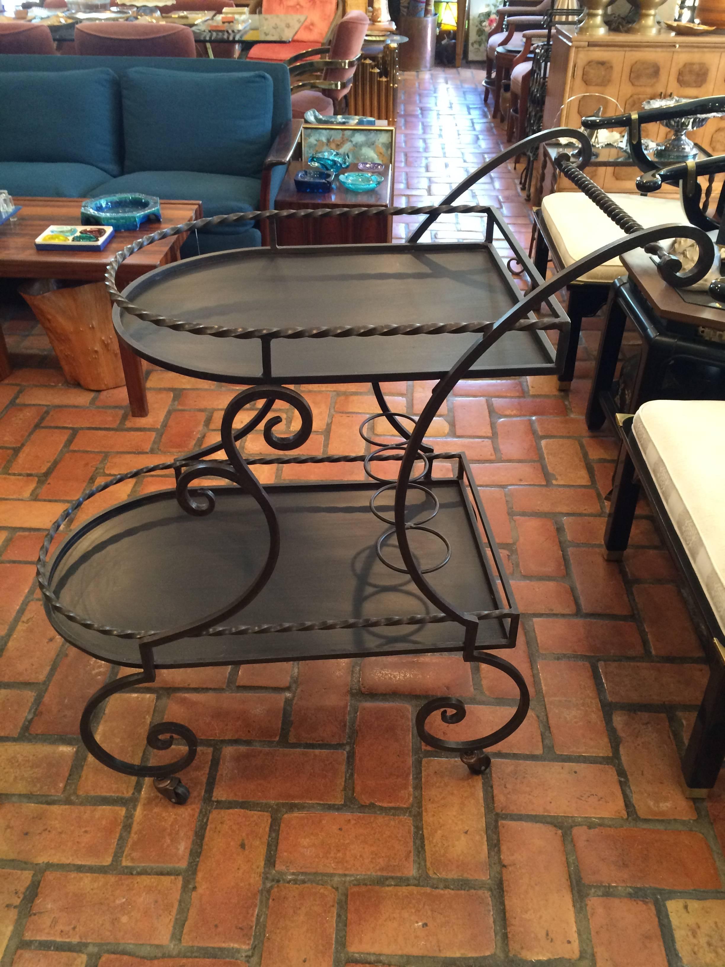 Wrought iron rolling tea or bar cart. Perfect for that afternoon tea on the porch. This elegant but sturdy cart has two tiers for food and drinks. It also has four bottle holders for a variety of refreshments.