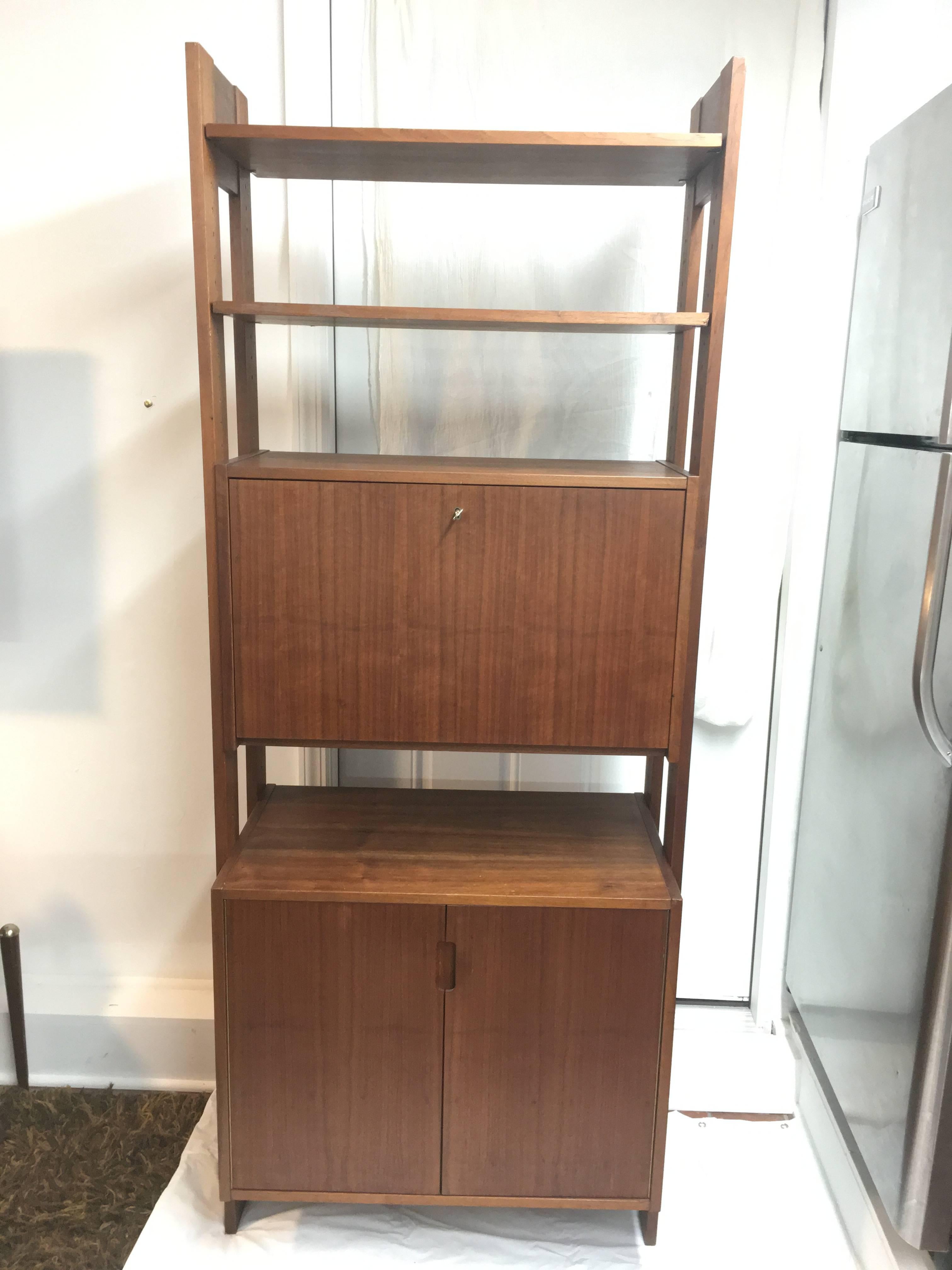 Mid Century Danish Teak Upright Bar or Desk. Perfect for limited space areas. Cado storage like unit with adjustable pieces and great storage. It has two upper shelves and a drop down bar with lined counter top to pour your beverages. Lower shelves
