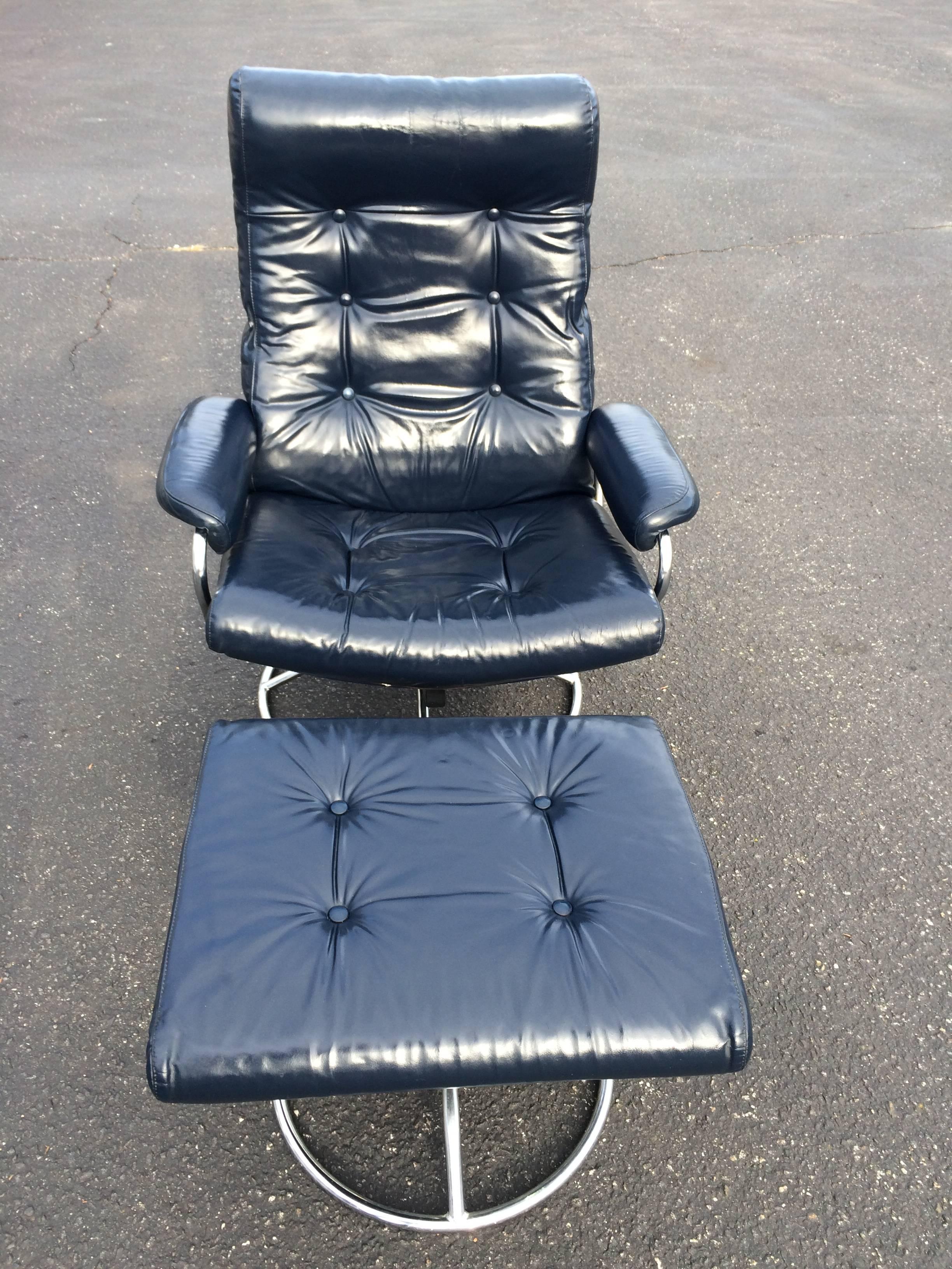 Leather Plycraft  Recliner lounge chair and ottoman in navy blue. Recliner is adjustable from upright to full recline and swivels. This ergonomic recliner comes with matching ottoman and both swivel. The backside of the recliner is covered in a blue