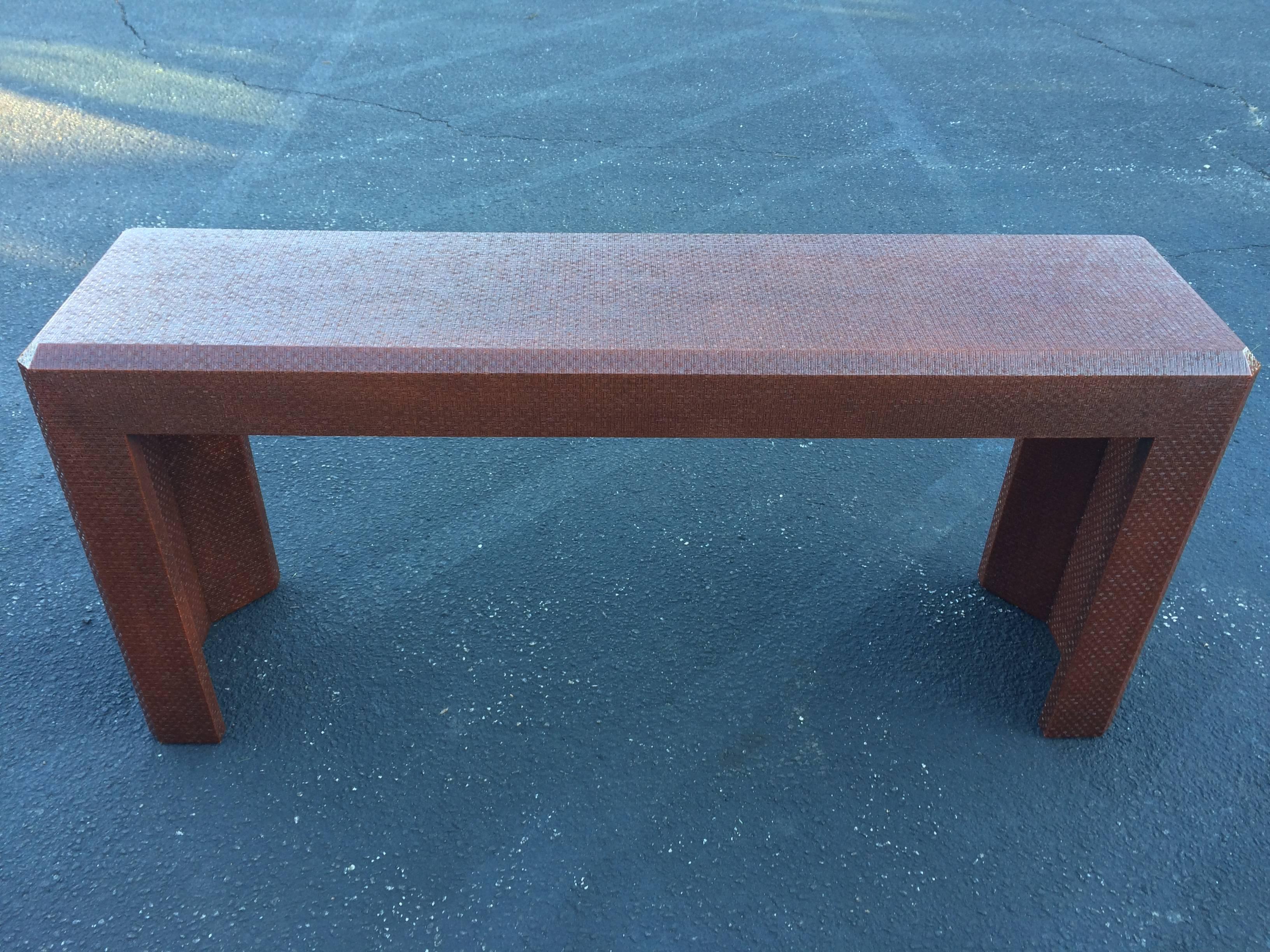 Textural Grass Cloth Wrapped Parsons Table in the style of Karl Springer. Rich honey Brown color with a woven herringbone pattern and a lacquered finish.The classic yet simple lines of this parsons table will bring a sleek look to any room. This