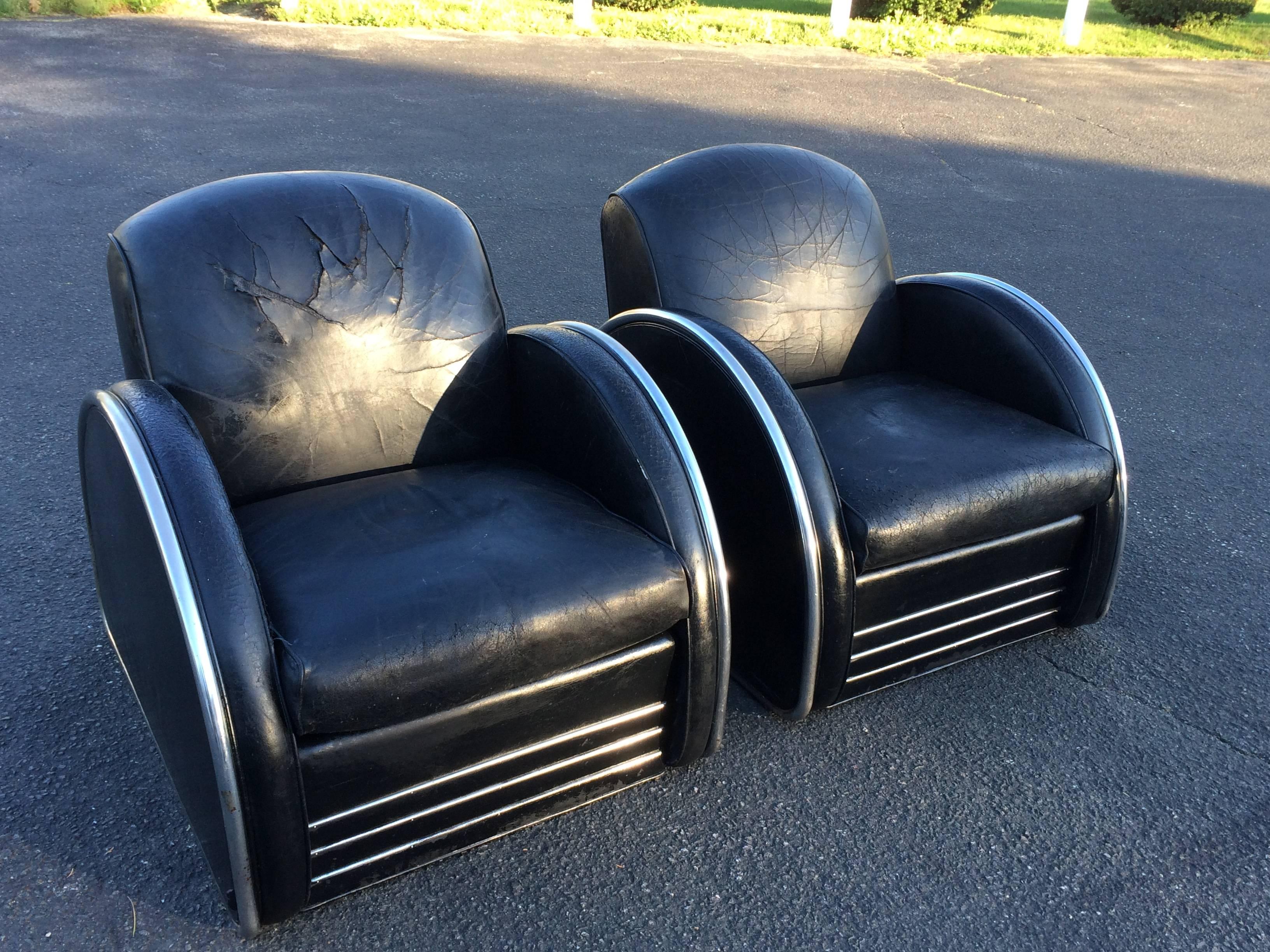 Pair of distressed leather Art Deco club chairs. Classic rounded arms with tubular chrome trim accents these streamlined machine age chairs. Obviously well loved and well used these chairs have very distressed leather to the point of cracking and
