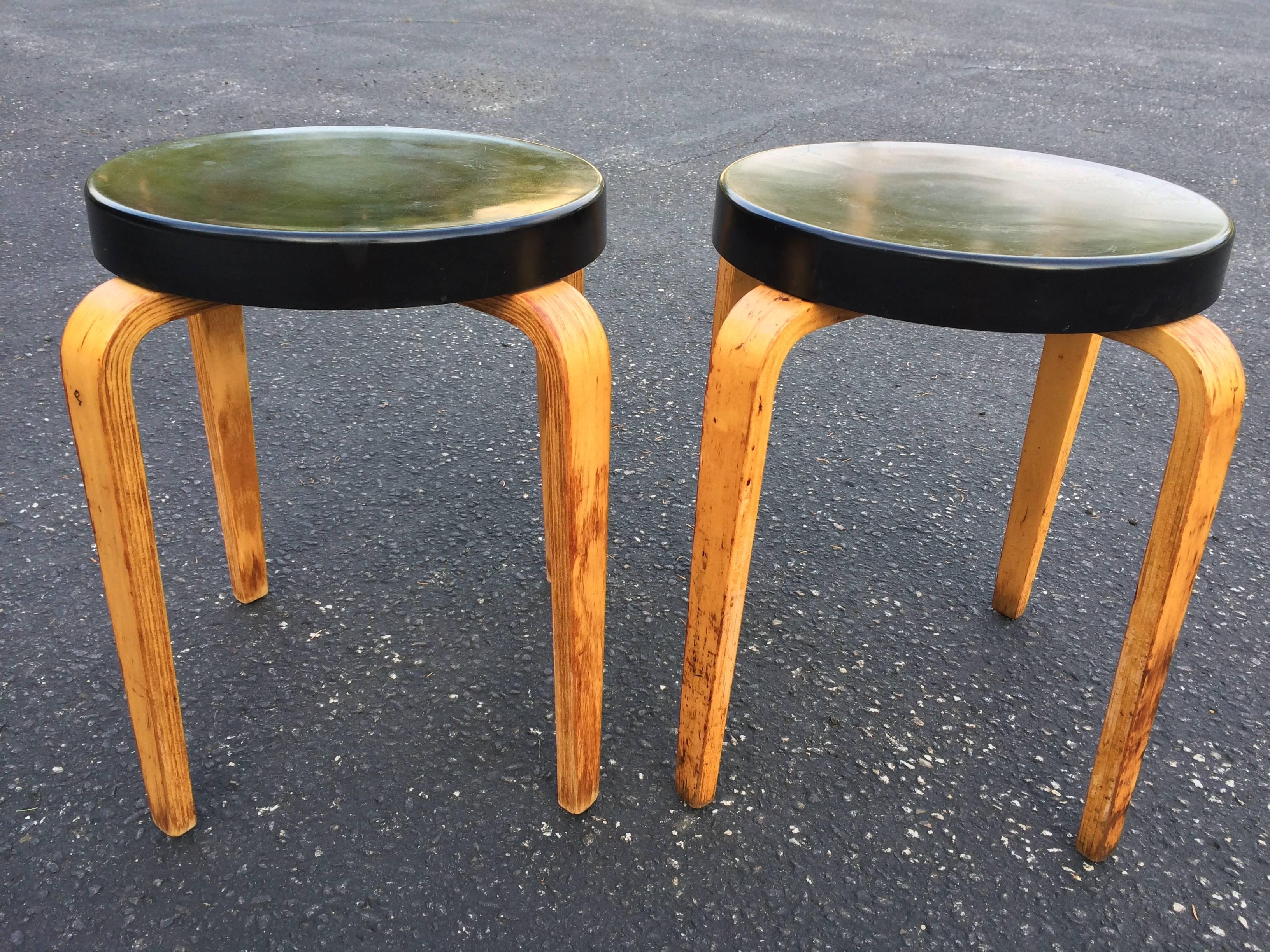Pair of authentic Thonet stacking stool tables. Classic black hard plastic top with bentwood legs. Signed Thonet underneath. One stool table has a slight 6