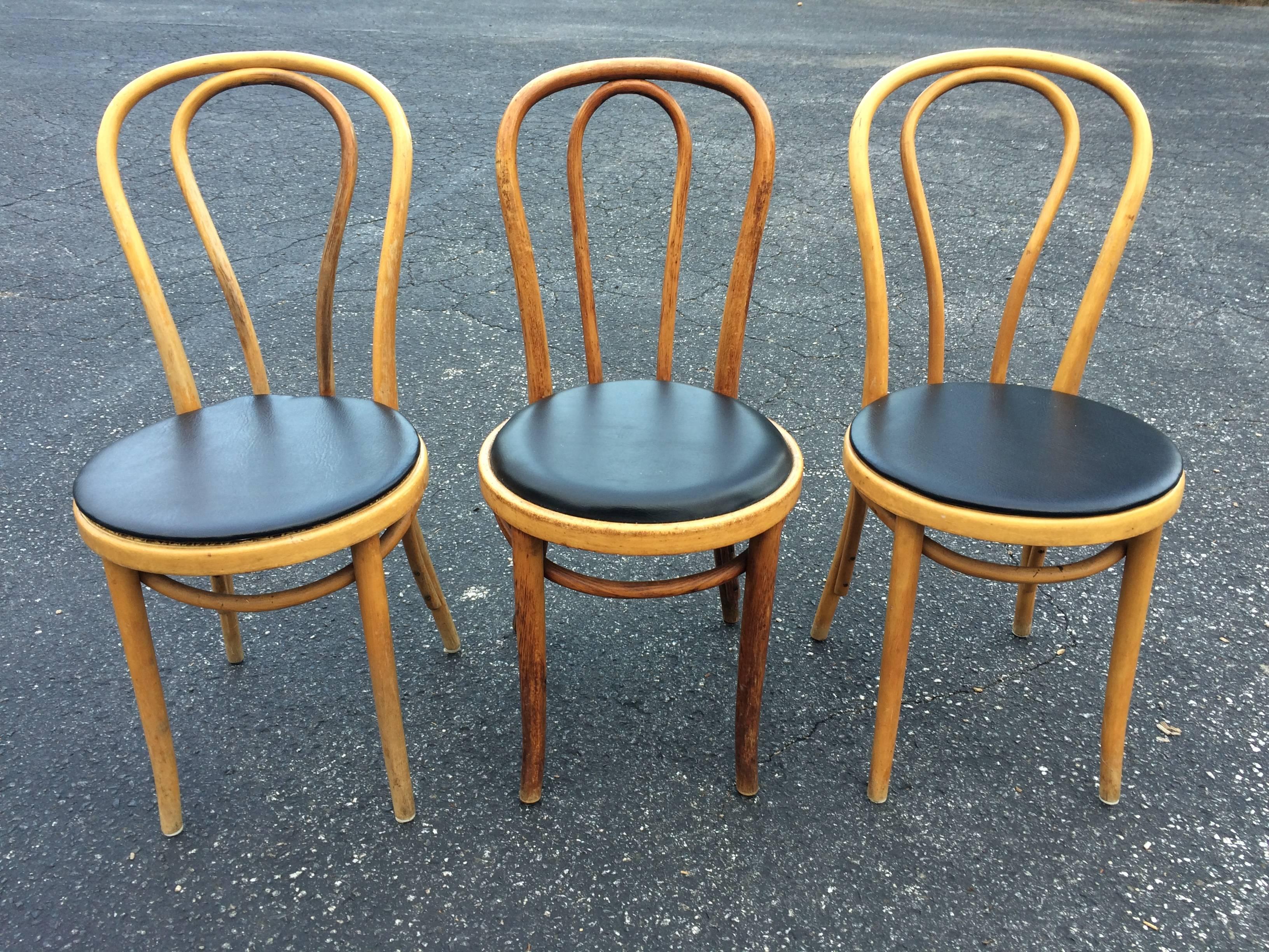 Set of three Thonet style bentwood stools. No. 18. Black Vinyl seat covers. One chairs seat needs repair, see photo.