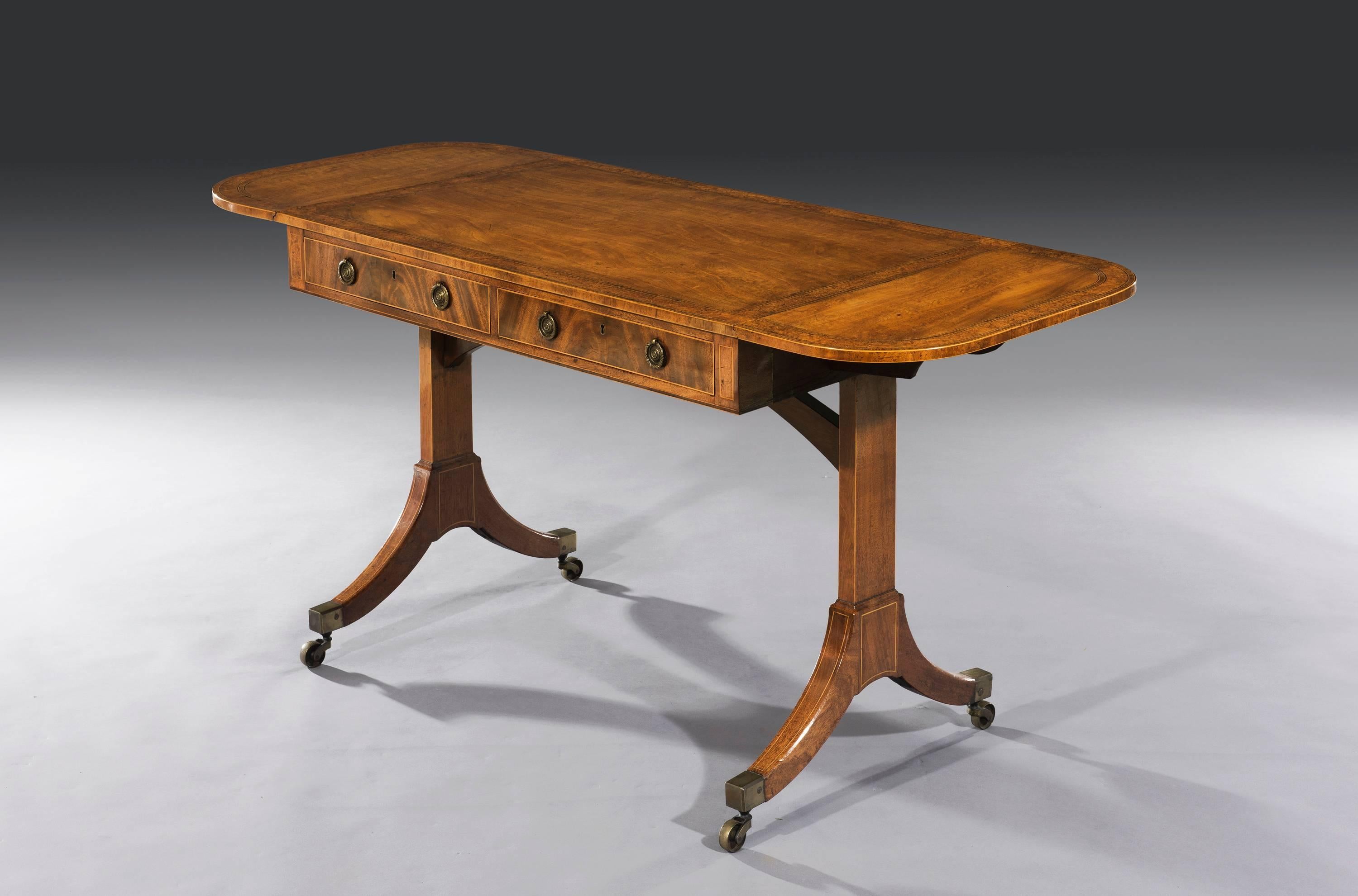 A late George III mahogany and pollard oak crossbanded and tulipwood sofa table. The rectangular top veneered with well figured mahogany, banded in pollard oak and cross banded in tulipwood. Below two frieze drawers and two dummy drawers arranged in