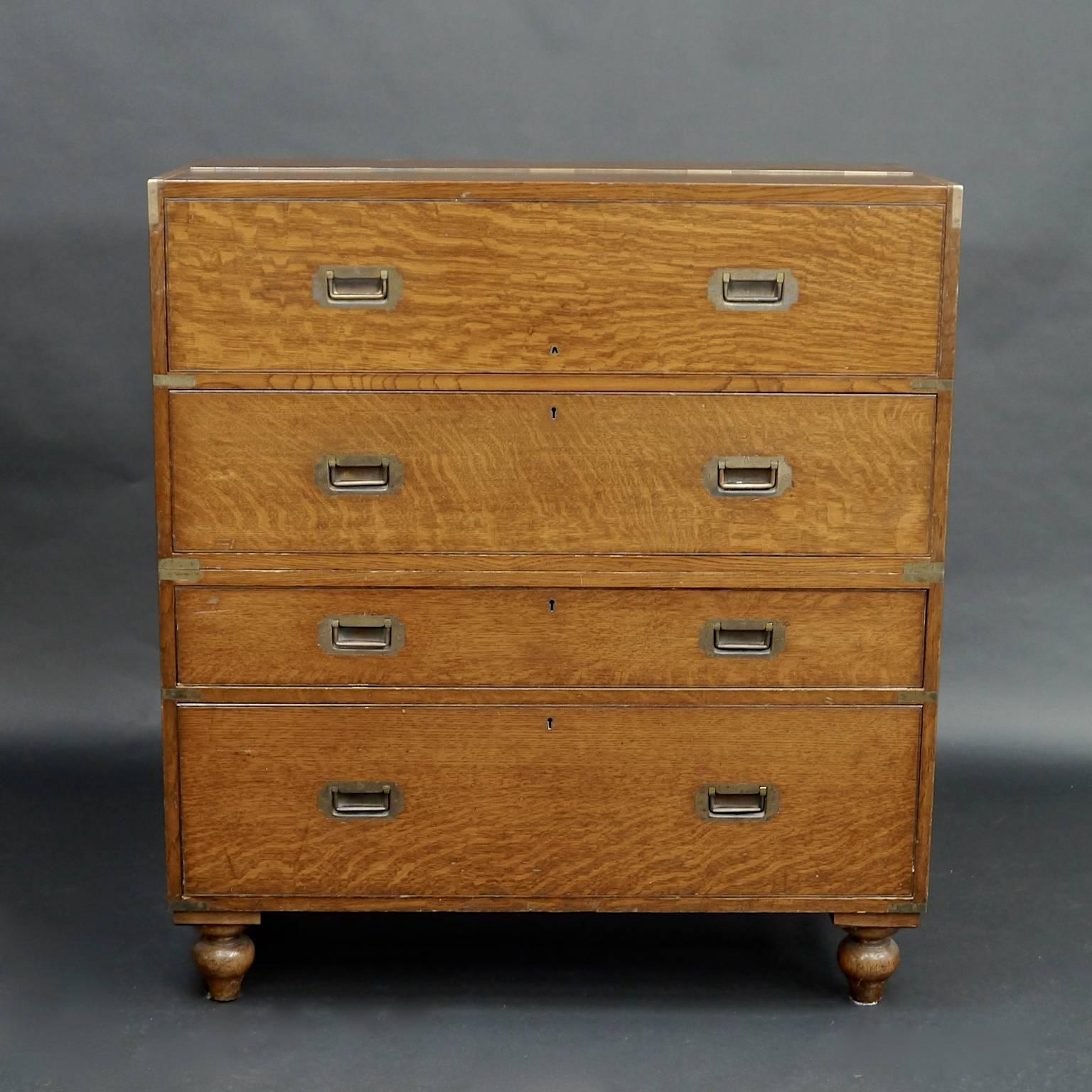 A fantastic two-piece solid oak Campaign chest with recessed brass handles and comprehensive secretaire drawer with slide out desk top and unusual folding mechanism that provides two smaller cupboards to the top. Manufactured and retailed by Army
