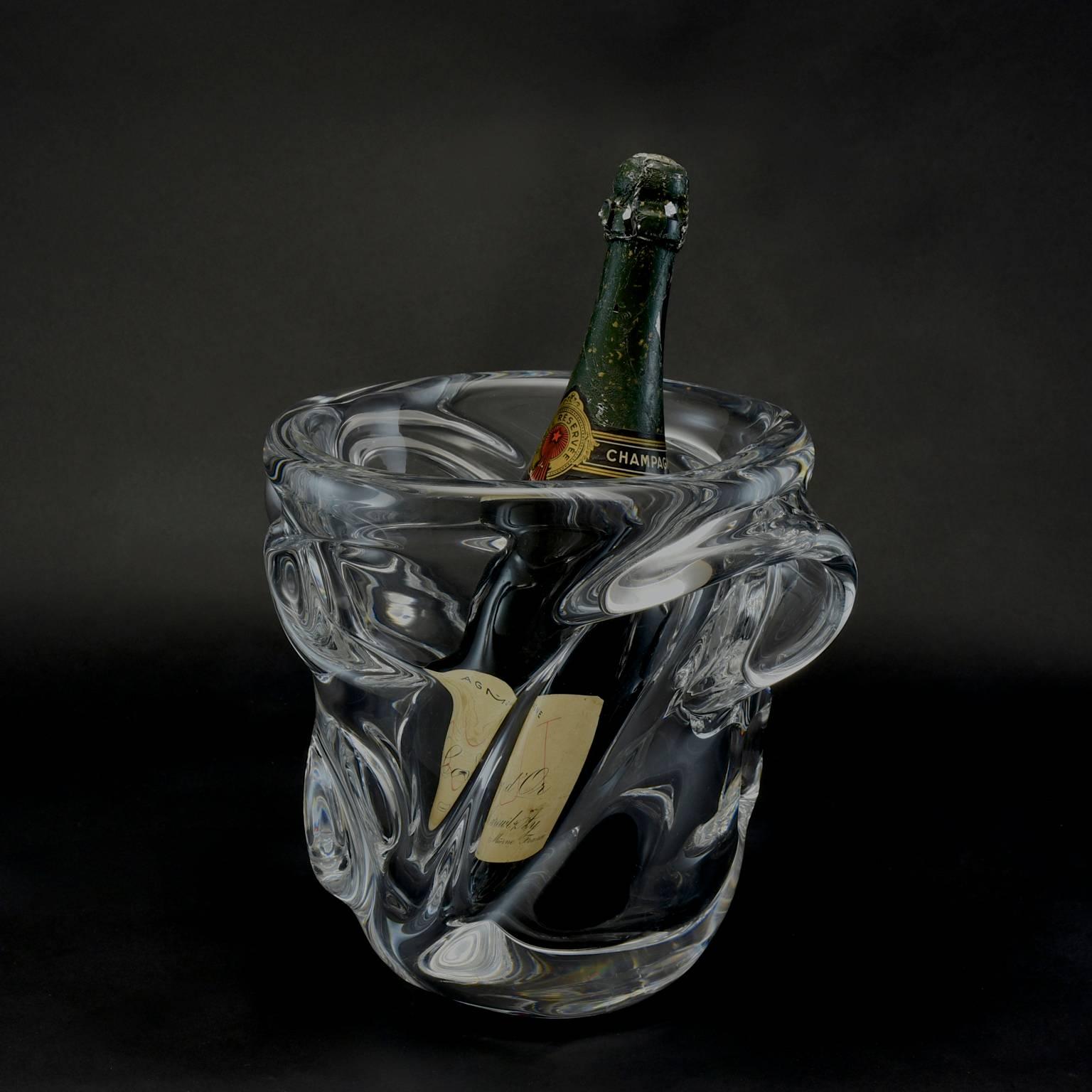 A spectacular midcentury champagne bucket or wine cooler made of heavy lead crystal in flowing shapes. Made by the glassworks of Cristalleries de Vannes-le-Châtel and acid etched on the base 'Sévres France'. In wonderful condition with the original