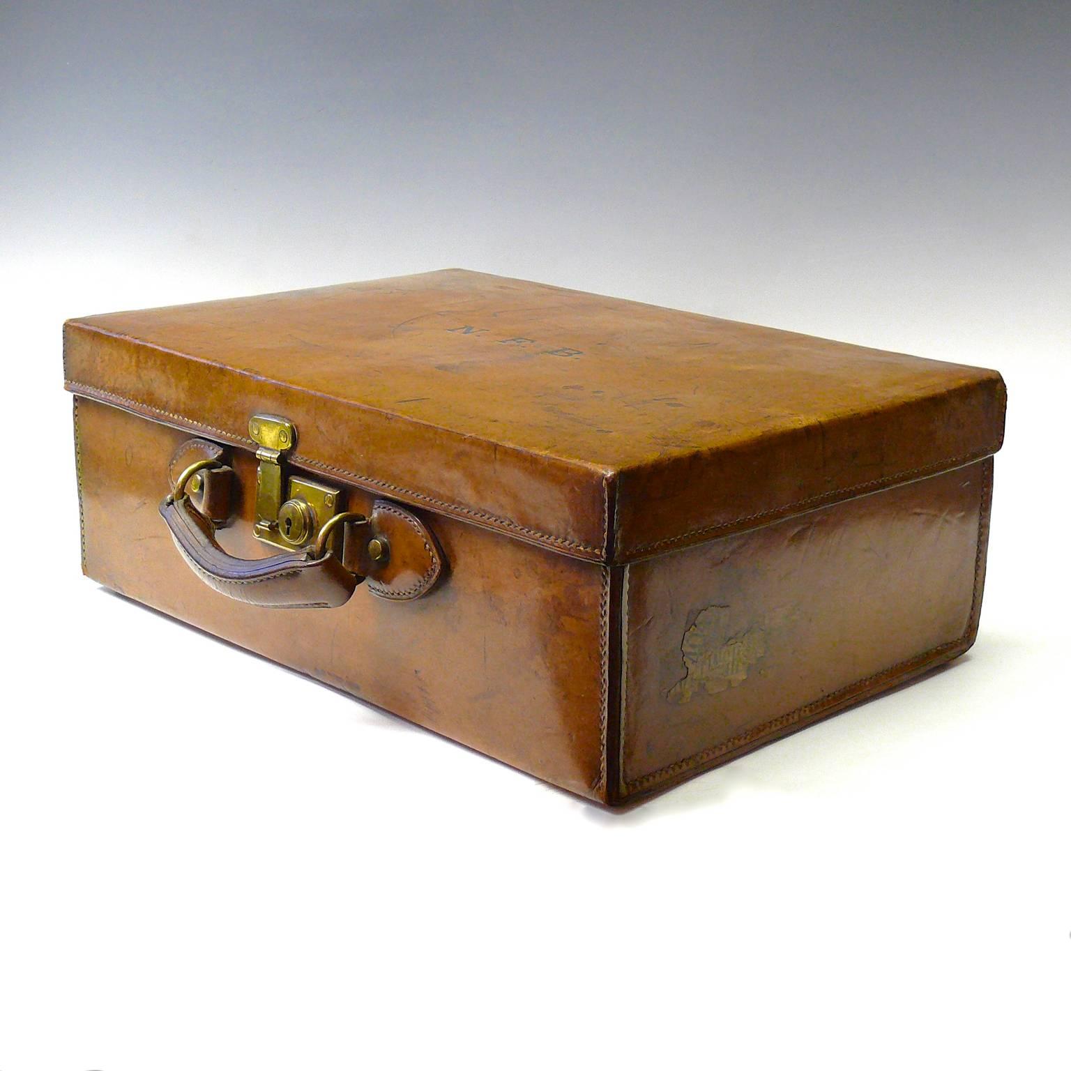 An attractive leather case with rich patina and initials N.F.B. to the lid. Stitch holes to the original leather interior show that this was a fitted case that has had the original pockets and pouches removed, circa 1910. This would make the perfect