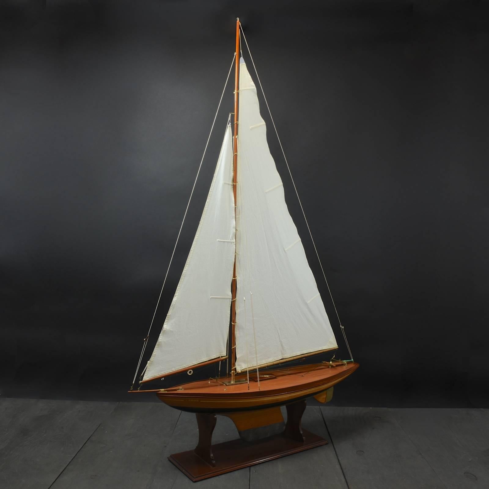 An elegant Bermudian rigged pond yacht named ‘Grace', circa 1935. Constructed with a part painted plank on frame hull, beautifully curved planked deck, brass rudder and a lead keel. The model utilizes a balanced main sail method of steering. The
