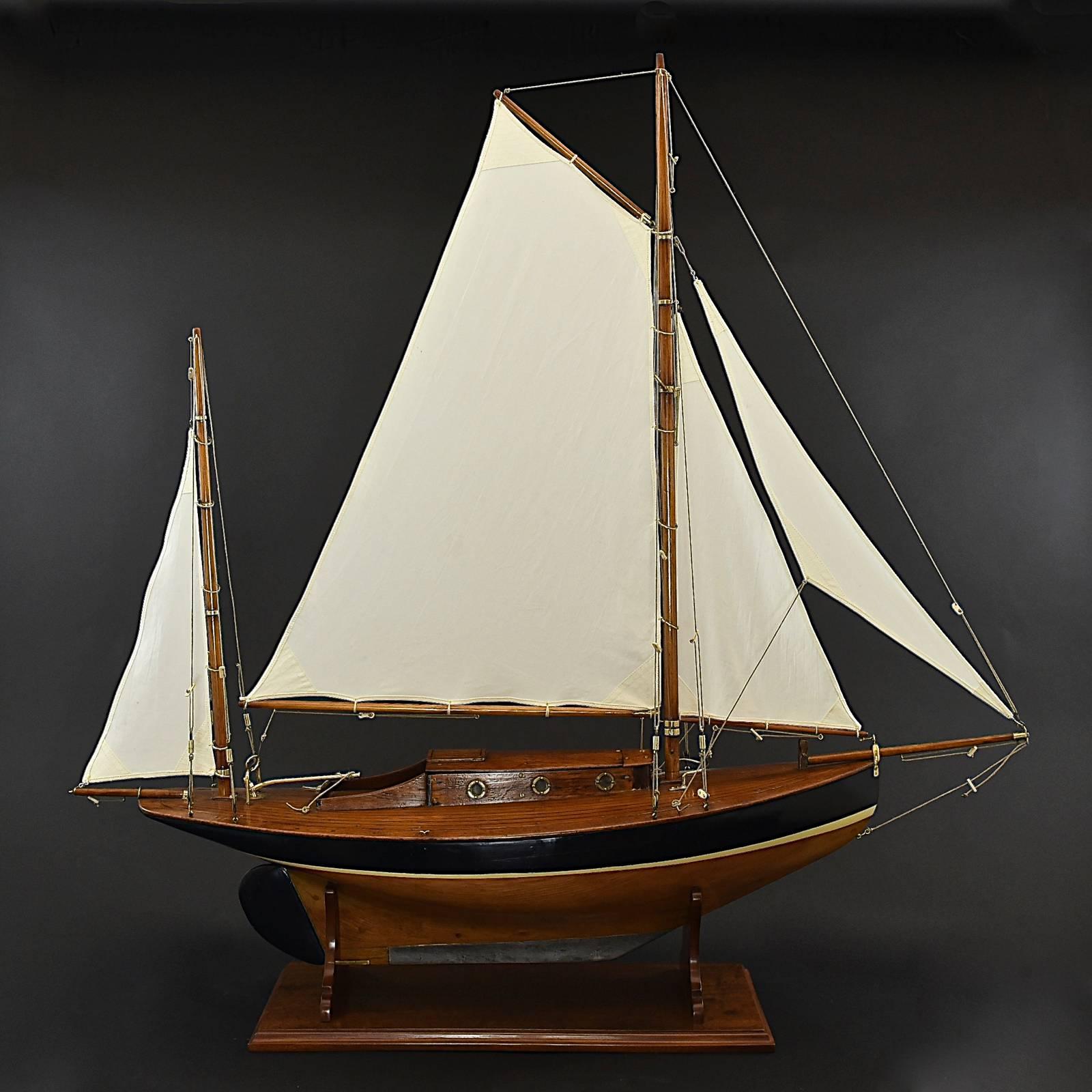 A lovely model Yawl, circa 1925 with a bow sprit, lead keel, gaff rigged main mast and a mizzen mast aft. Unusually it has a well-detailed cabin with handmade brass portholes and rudder.
The cotton sails are replicas of the originals and the model