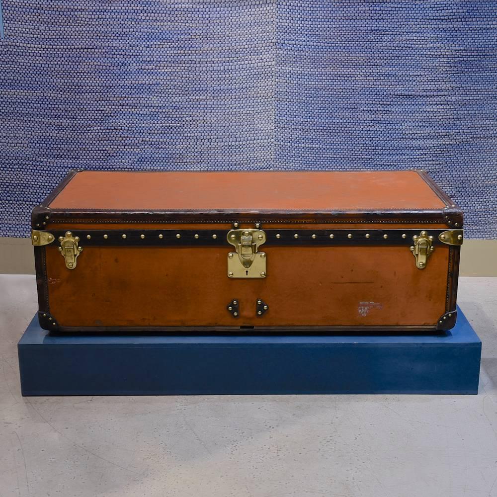 A large cabin trunk in orange Vuittonite with with brass fittings and leather trim; circa 1910. With re-lined interior.

Dimensions: 110 cm/43¼ inches (length) x 55 cm/21¾ inches (depth) x 35 cm/13¾ inches (height).

We are members of LAPADA,