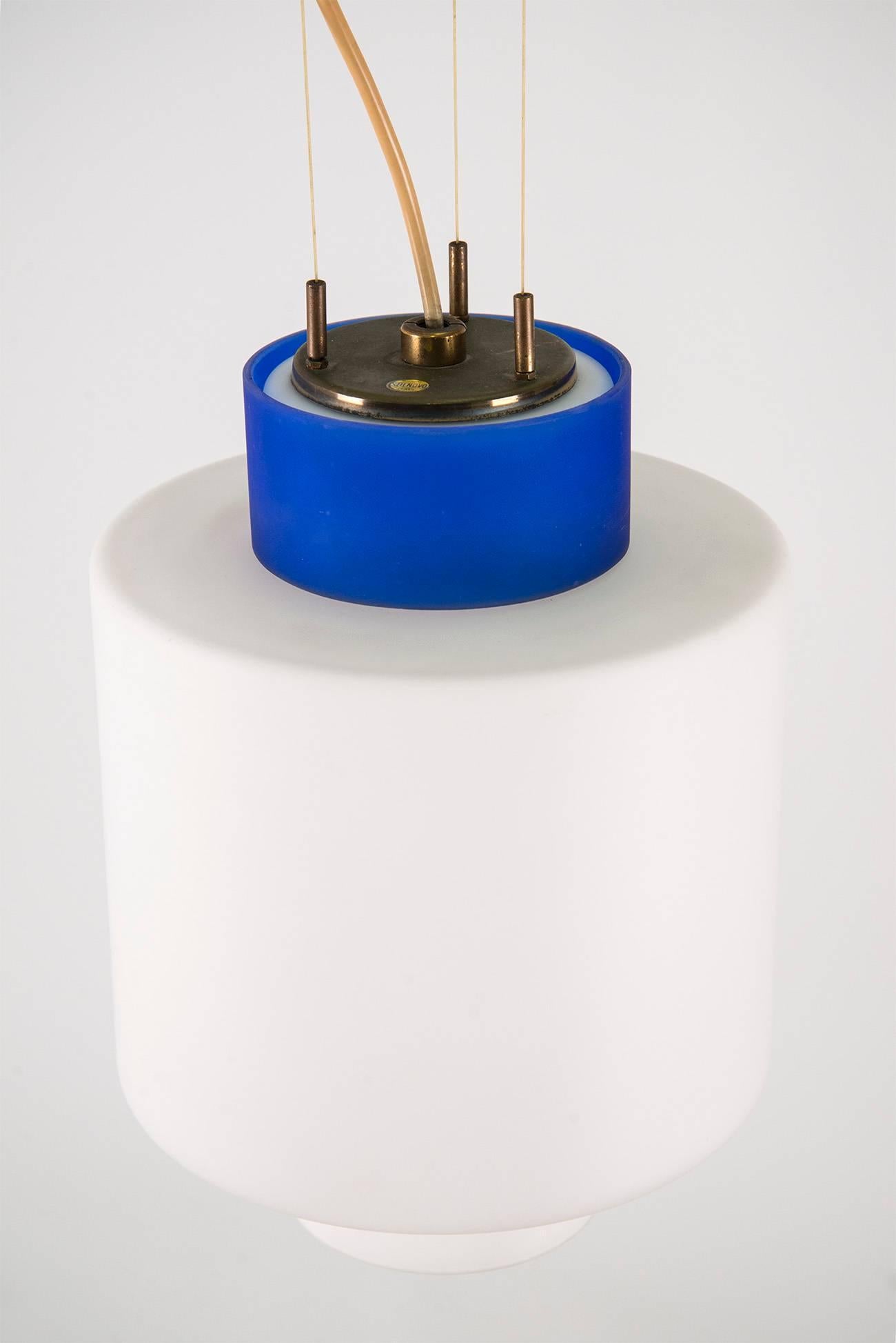 Pendant with a blue and white encased frosted glass diffuser and brass elements, manufactured by Stilnovo in the 1950s. Manufacturer's decalcomania on the upper part of the shade.