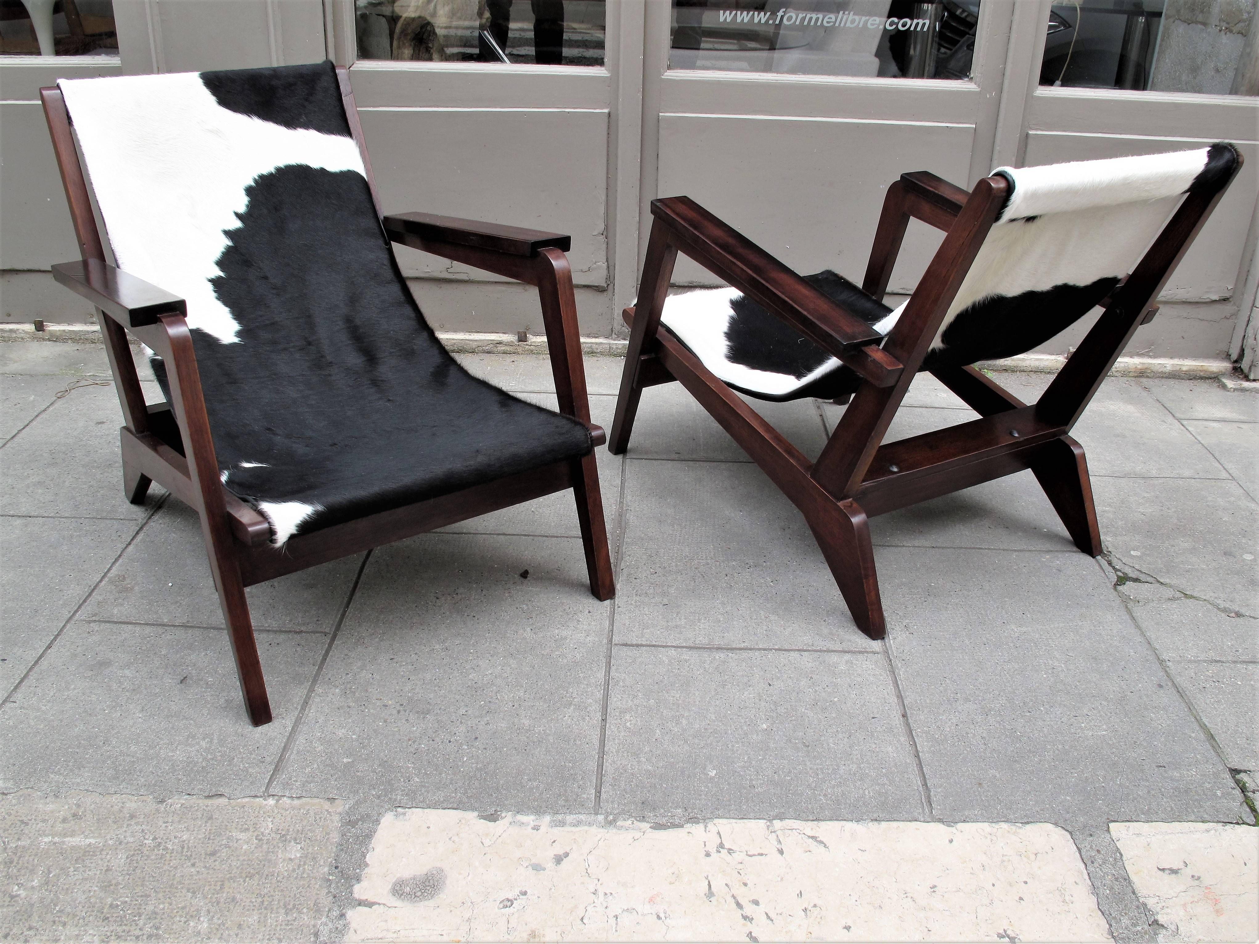 A pair of wooden chairs in mahogany and cowhide.
French work of the 1940s-1950 from Grenoble where Pierre Jeanneret worked after the second war.