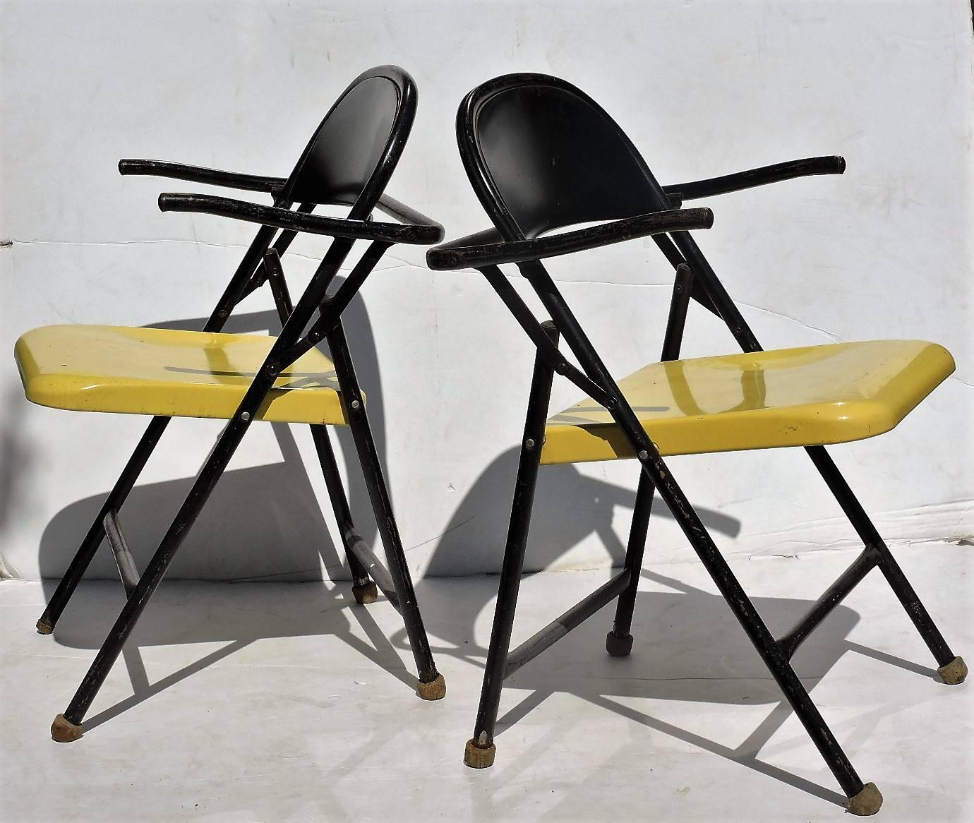 A pair of Bauhaus style sleek grasshopper form metal folding chairs in original black and yellow enameled painted surface with a beautifully angled architectonic sculptural design, circa 1950s. These will fold for parcel shipping, see image 8.