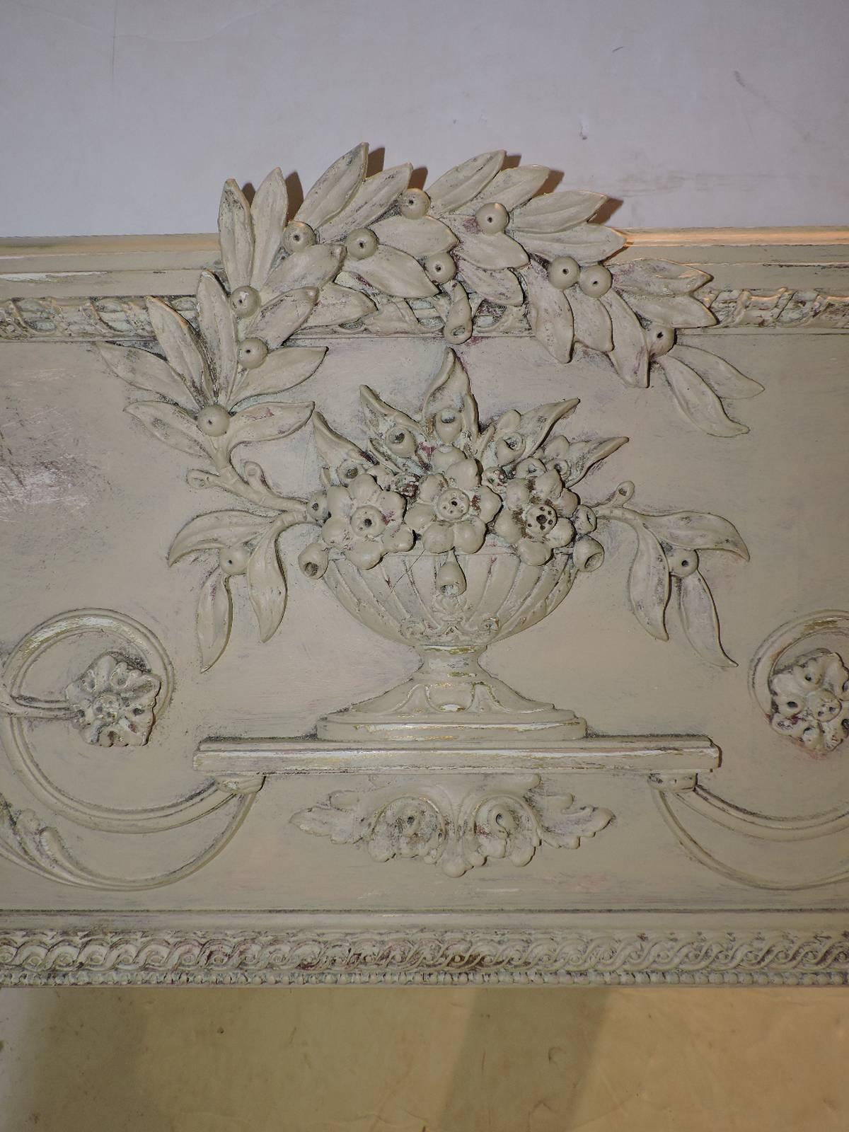 A Louis XV style trumeau mirror by D. Milch & Son with a carved urn & foliate design in relief. The original surface repainted in a lightly aged worn soft cream white finish. See all pictures.