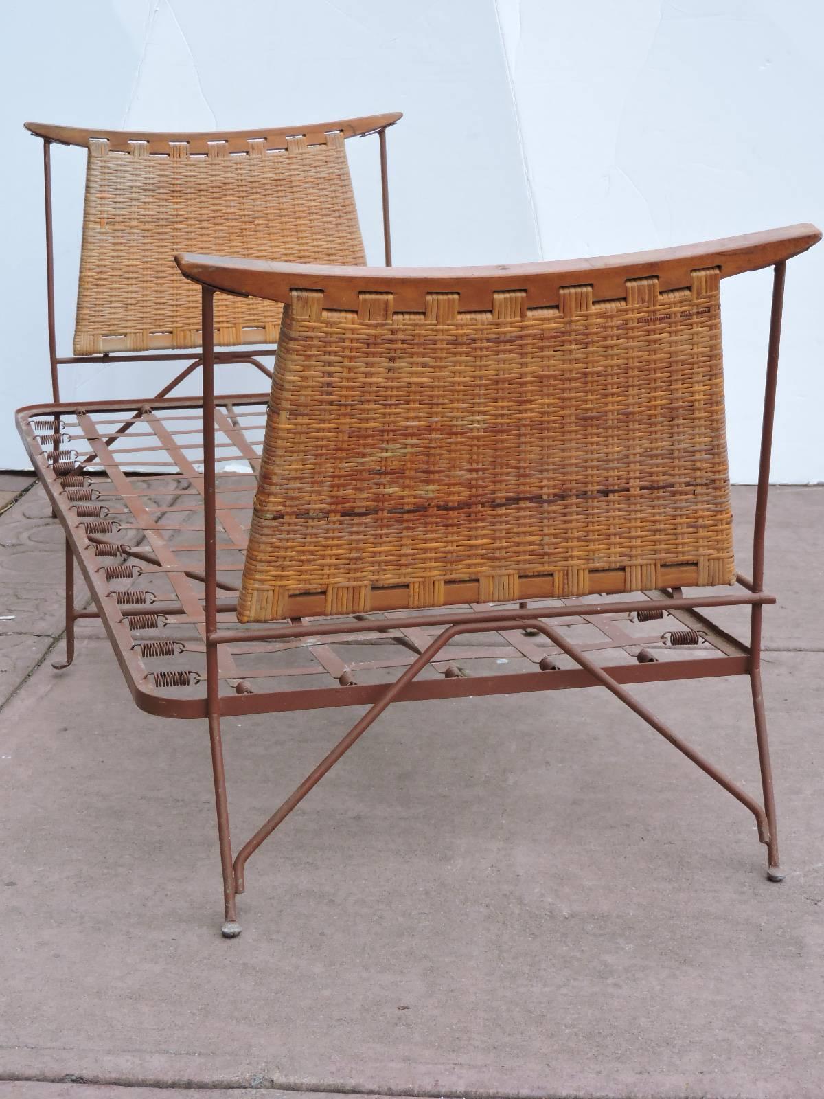 A mid 20th century wrought iron, wood and natural woven wicker cane daybed lounge with a striking sculptural form and all over beautifully aged original color patina. Possibly an obscure design by John Salterini - we have yet to see another one