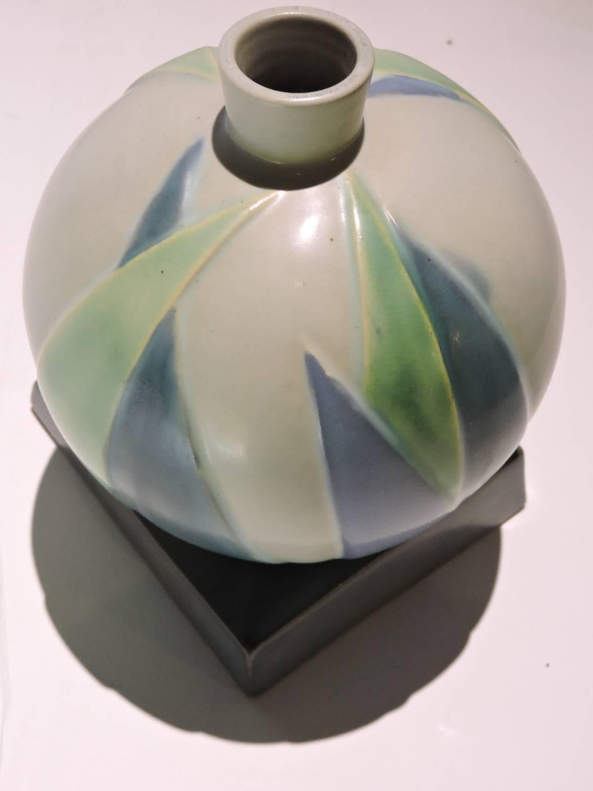 A Roseville Futura American Art Deco design vase having a trapezoidal base balancing a ball form with stylized raised lotus leaves. Guaranteed 100% vintage Roseville Pottery dating from the 1920s.