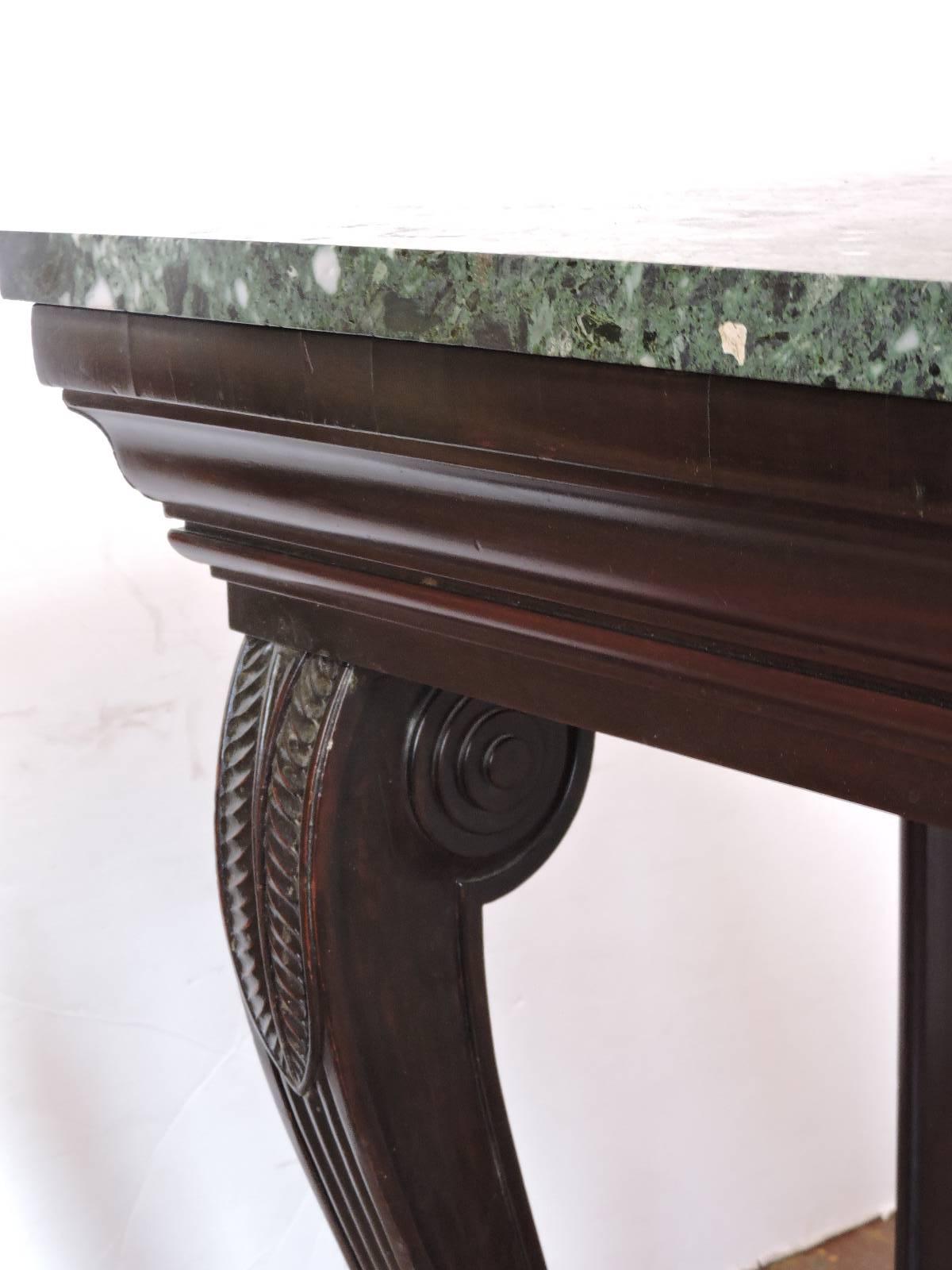 A gracefully designed large 19th century classical American Empire carved mahogany console table with beautifully curved acanthus design legs ending in paw feet and a variegated heavy green marble top. Great table for home or commercial restaurant