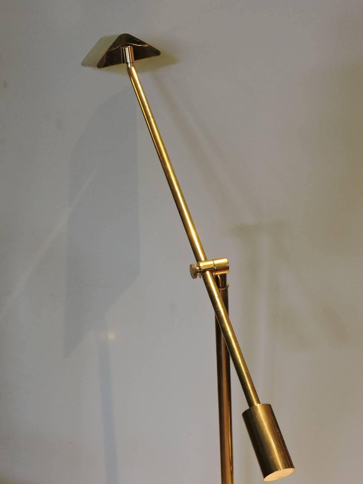 A very high quality heavyweight golden brass pharmacy style floor lamp by Frederick Cooper with an adjustable height armature and a shade that can be pivoted in a wide range of positions. The brass is in great original condition and the electric