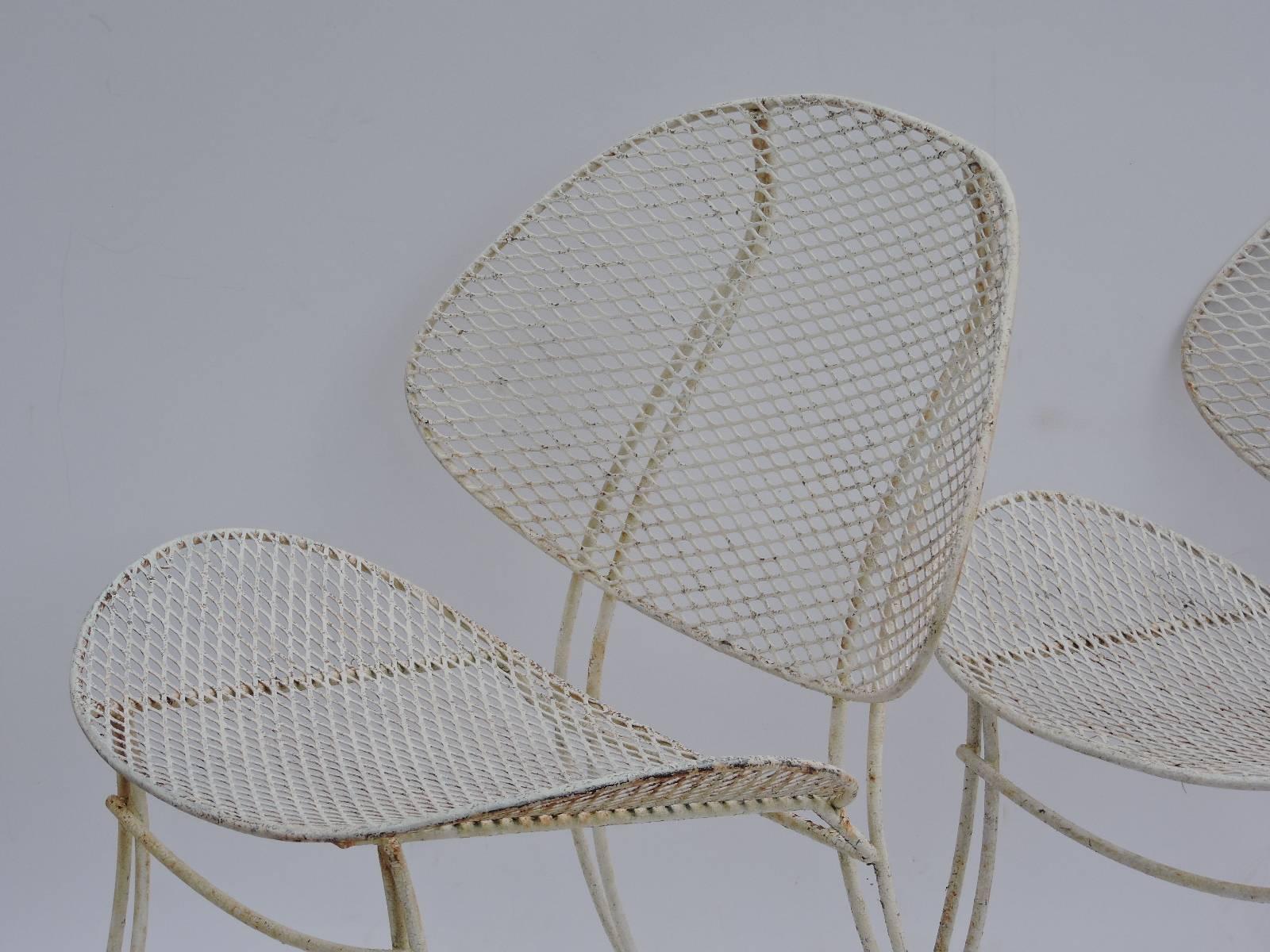 A pair of sculptural mid 20th century wrought iron clam shell Casino chairs by Homecrest in nicely aged old soft white painted surface in the manner of Maurizio Tempestini for Salterini.