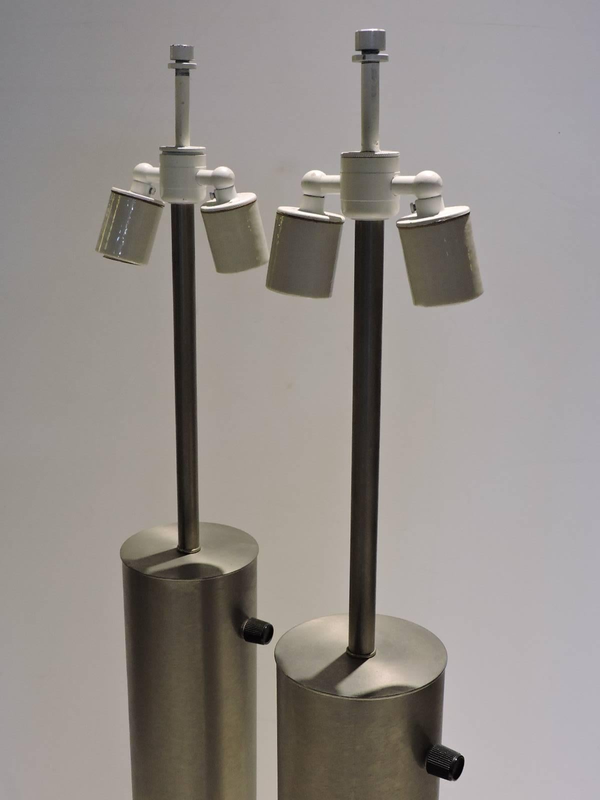 A pair of machine age modernist tall cylinder aluminum table lamps by Walter Von Nessen in very good all original vintage condition. Paper labels on bottom read Nessen Lamps, Bronx, NY.