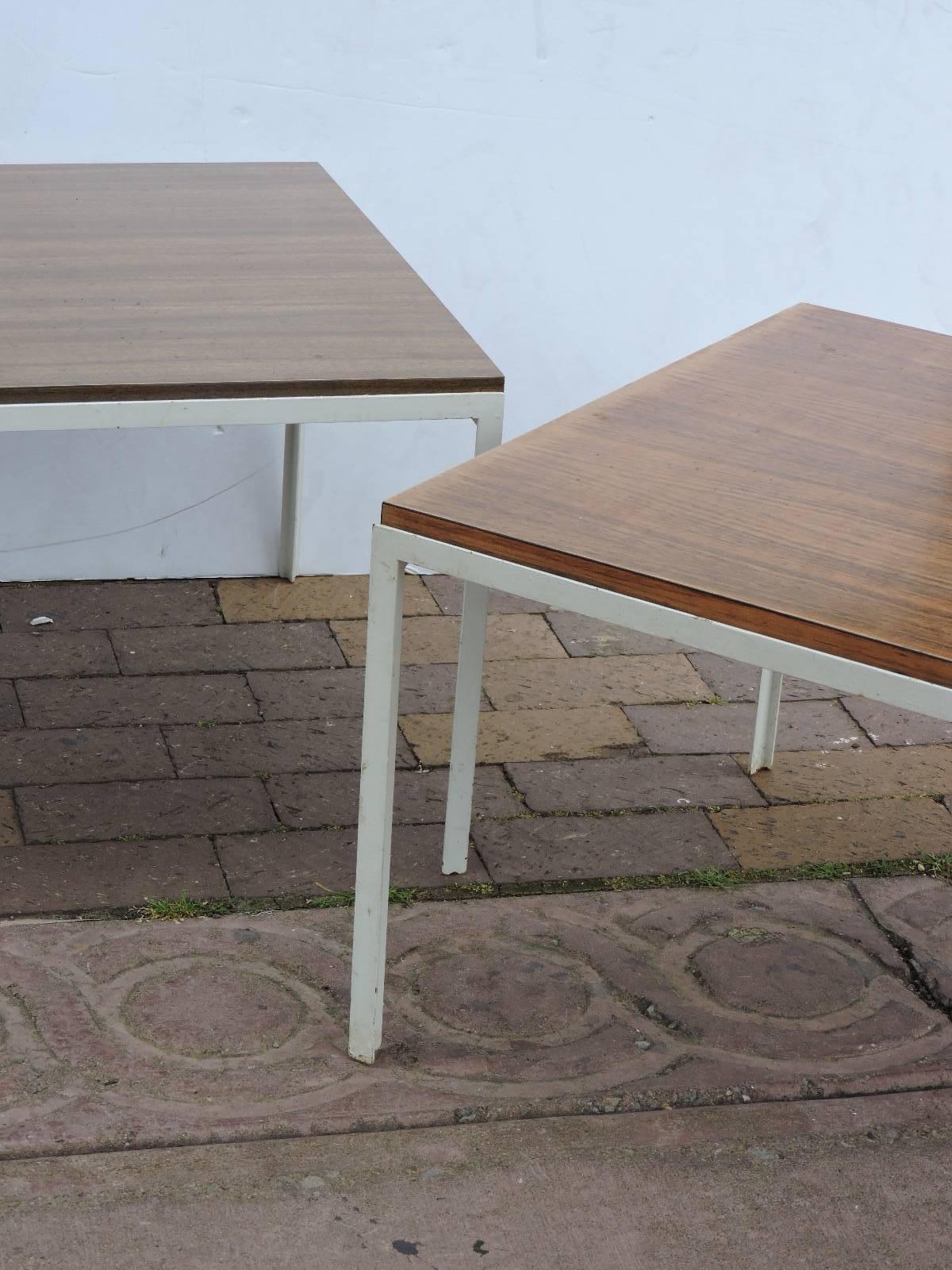 A pair of early all original 1950's Florence Knoll architecturally Minimalist designed T - Angle tables with white enameled steel bases and wood grained laminate tops.