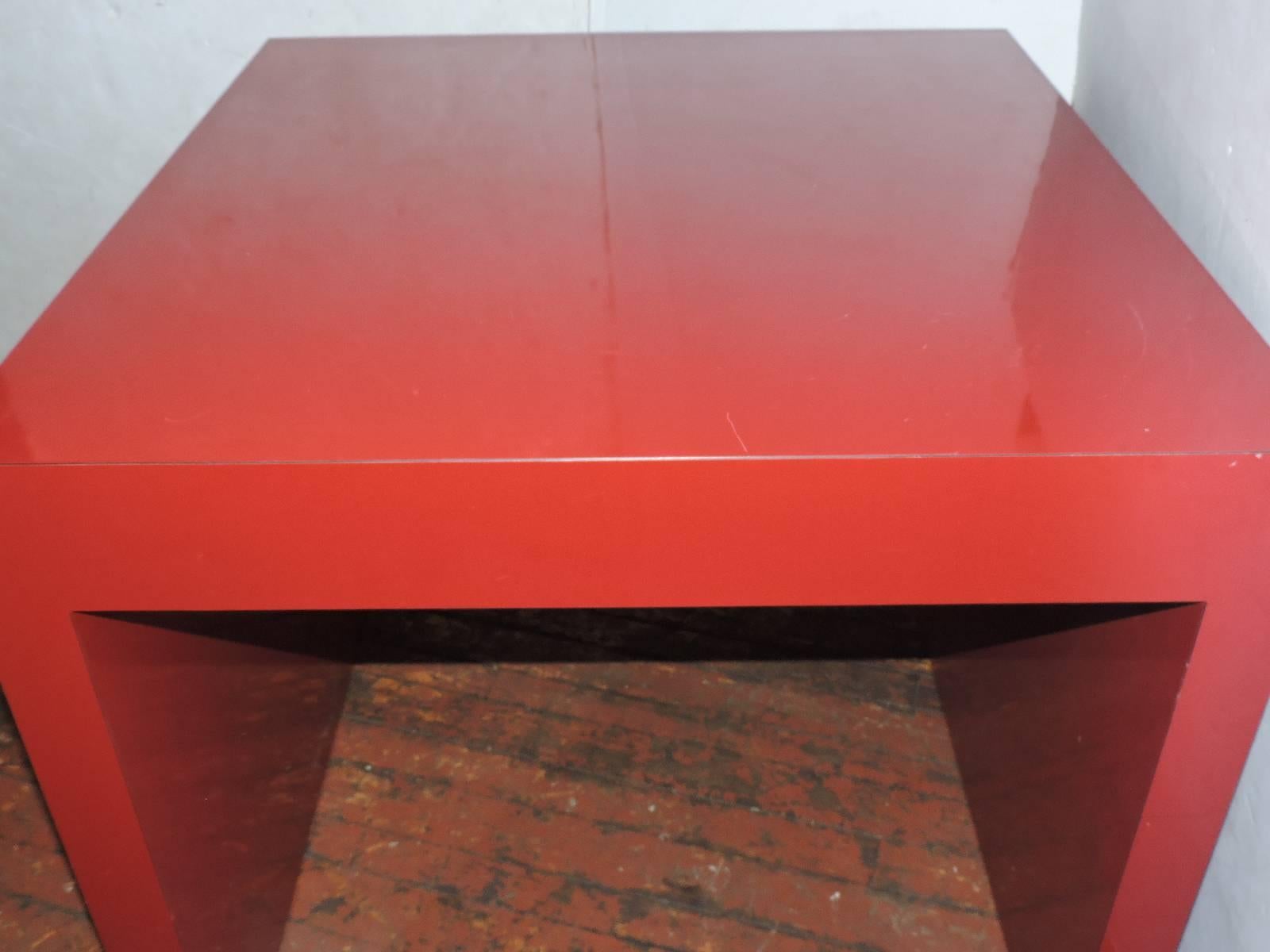 An unusually large-scale thick walled brilliant cherry red laminate Parsons table measuring 33 inches deep x 32 inches wide and 26 inches high. Side walls are about 2 1/2 inches deep and the top is about 4 1/2 inches deep. The open area is 27 inches