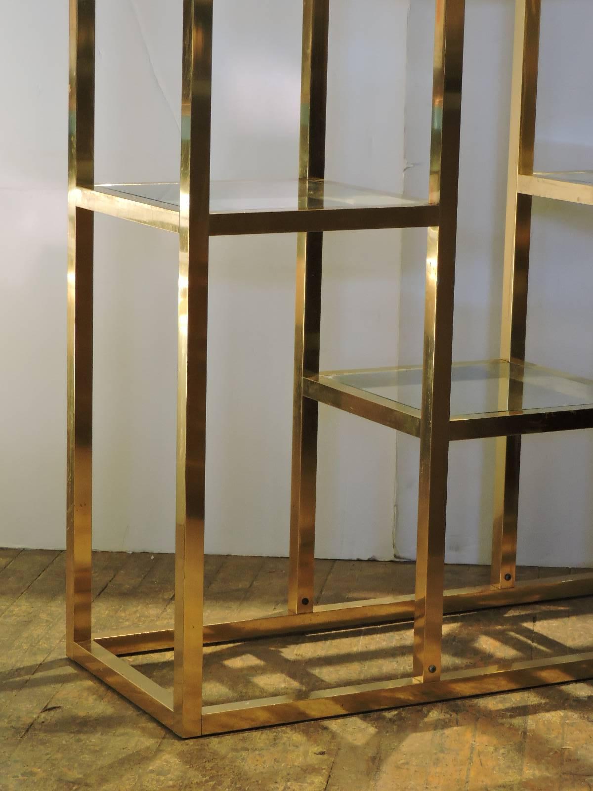 A good looking Hollywood Regency freestanding brass-plated etagere with seven square shaped glass inserts that rest on the four graduated pedestal like central shelves (center top pedestal with chrome-plated corner caps - picture 6) and the divided