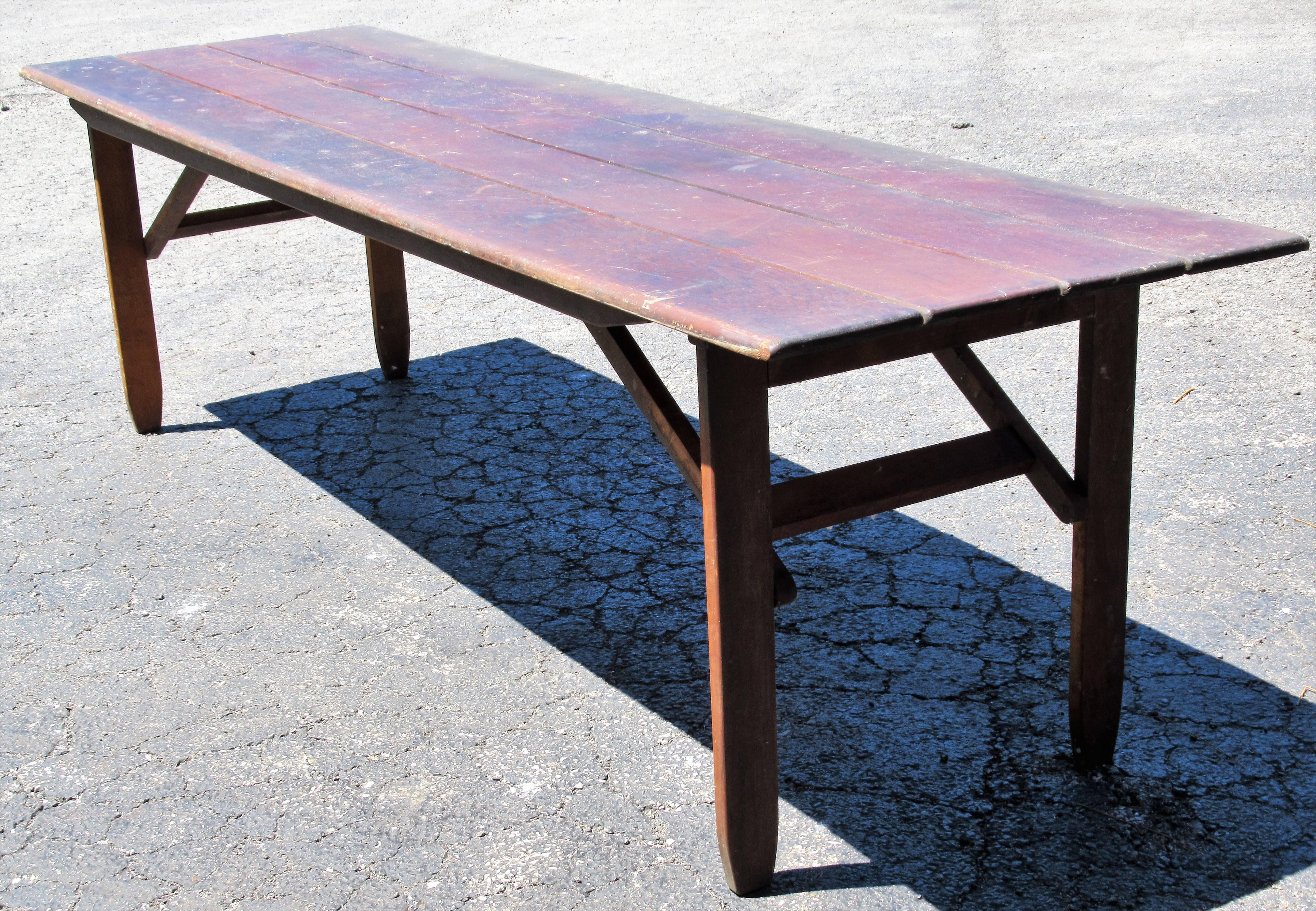 Nine foot long collapsible fold under leg harvest refectory campaign style dining table with nicely aged color patina to wood. Great form and a beautifully constructed custom designed table made by a skilled woodworker craftsmen about 50-60 years