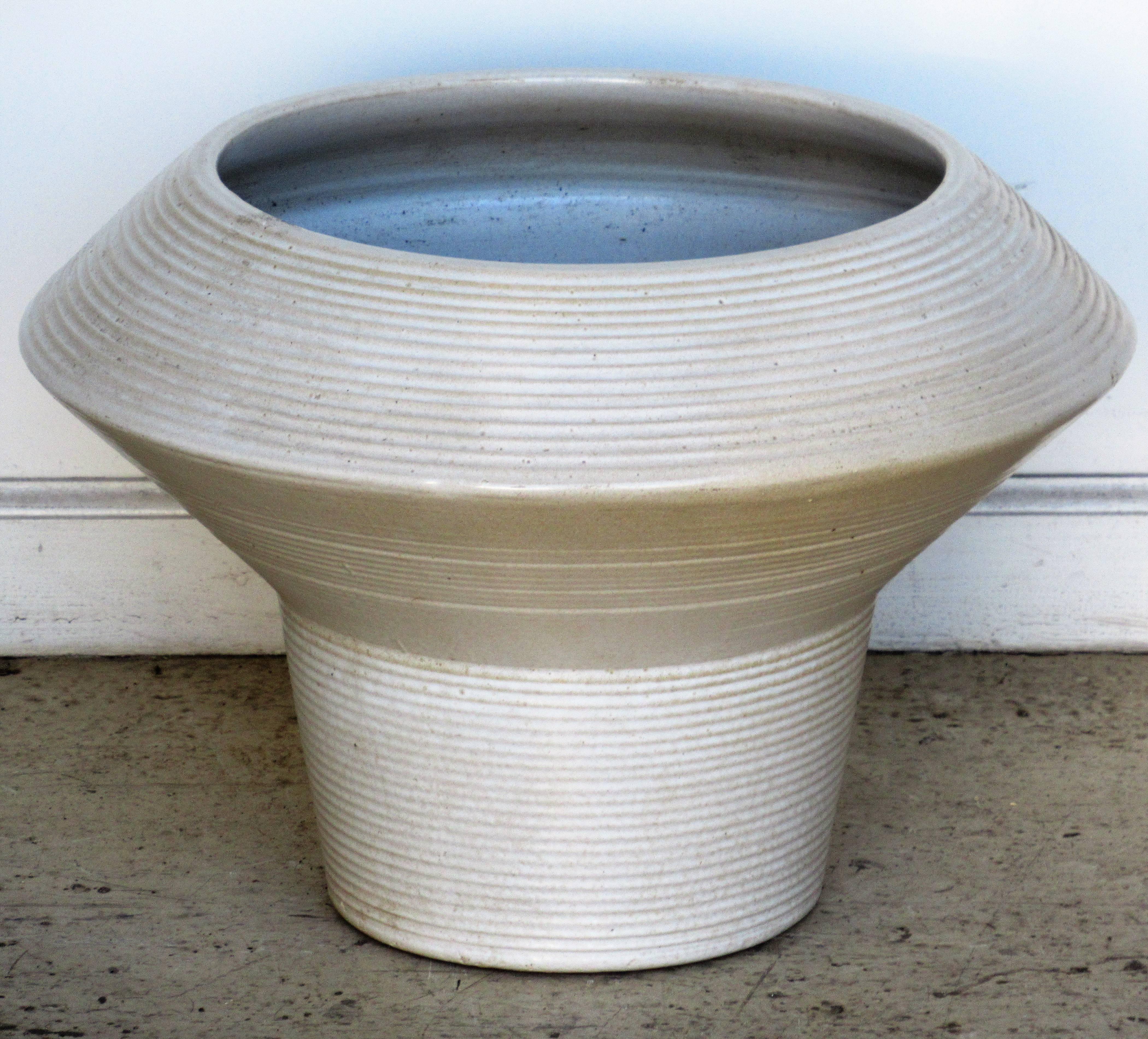 A very large sculptural modernist architectural pottery floor vase jardiniere planter with an all-over exterior ribbed design and a medium gloss oatmeal white glaze. Attributed to Zanesville - Stoneage Modern. Circa 1960