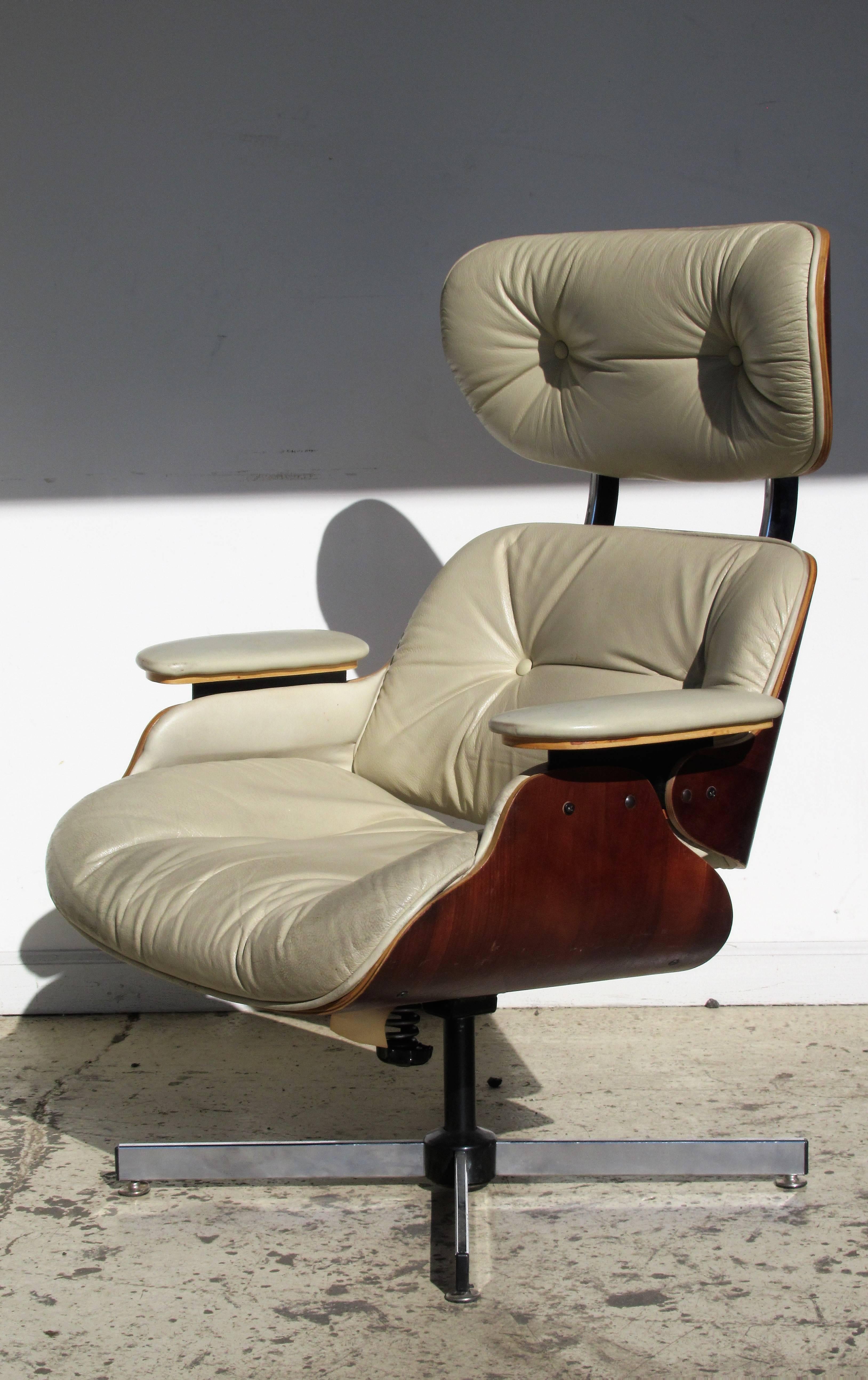 Plycraft swivel tilt lounge chair in hard to find pale cream leather upholstery overall beautiful color patina to richly grained wood. The chair in original good vintage condition.