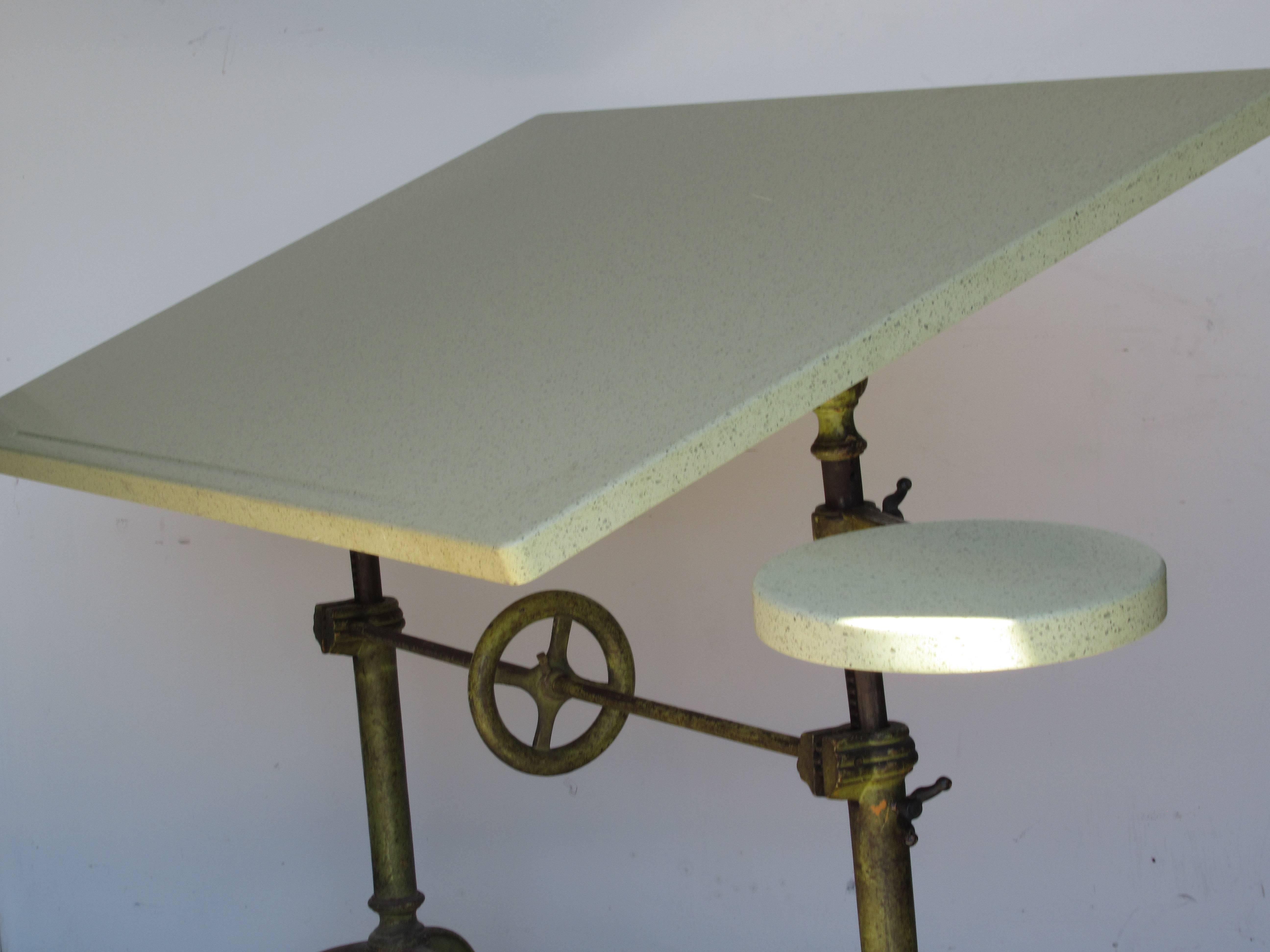 Antique American adjustable height Keuffel & Esser industrial architect drafting table with the best beautifully aged brilliant pea green painted cast iron base fitted with a contemporary custom speckled laminate over wood top and circular swing arm
