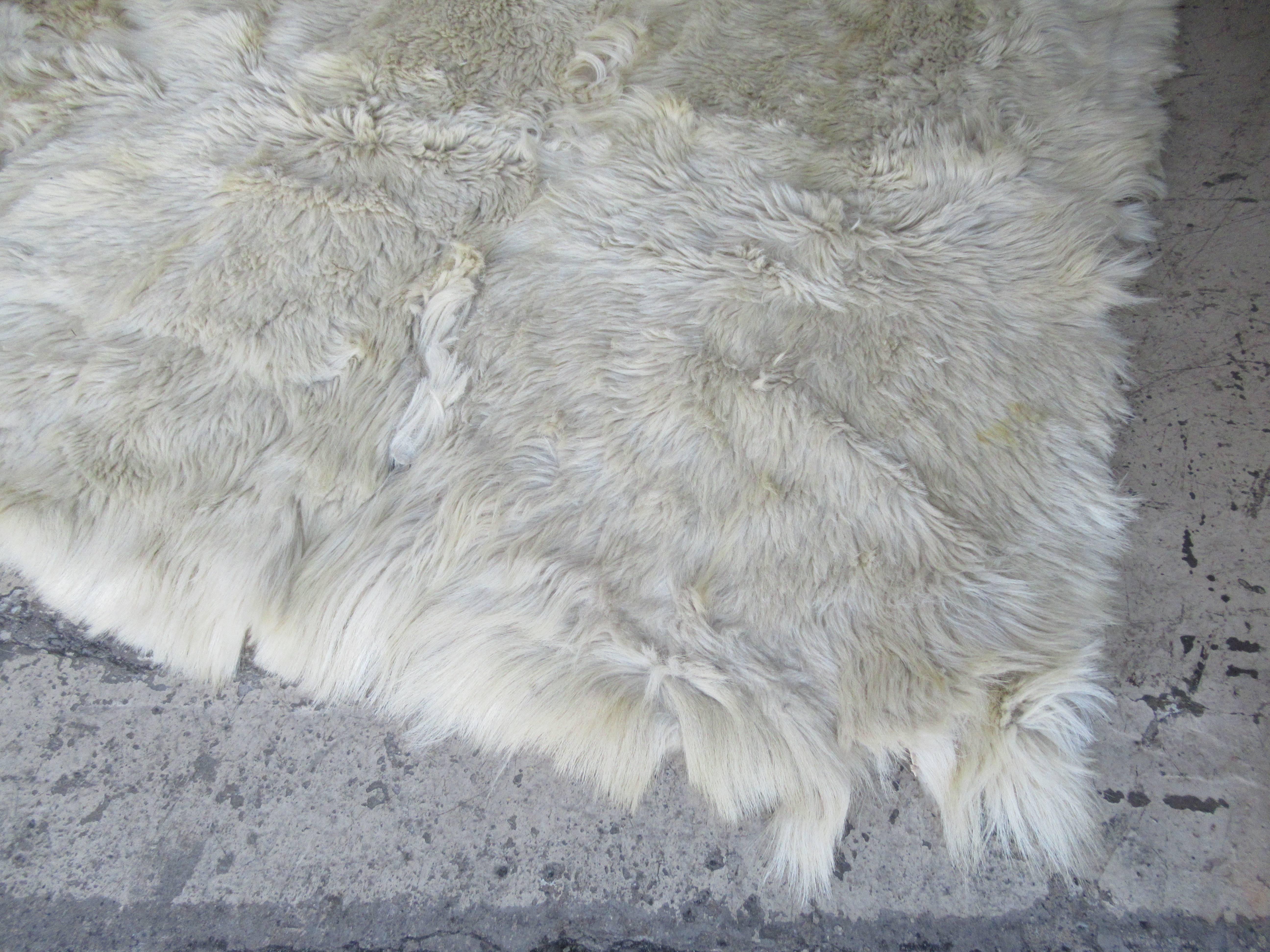 Vintage white long hair shaggy goat fur large area rug with original leather backing. 