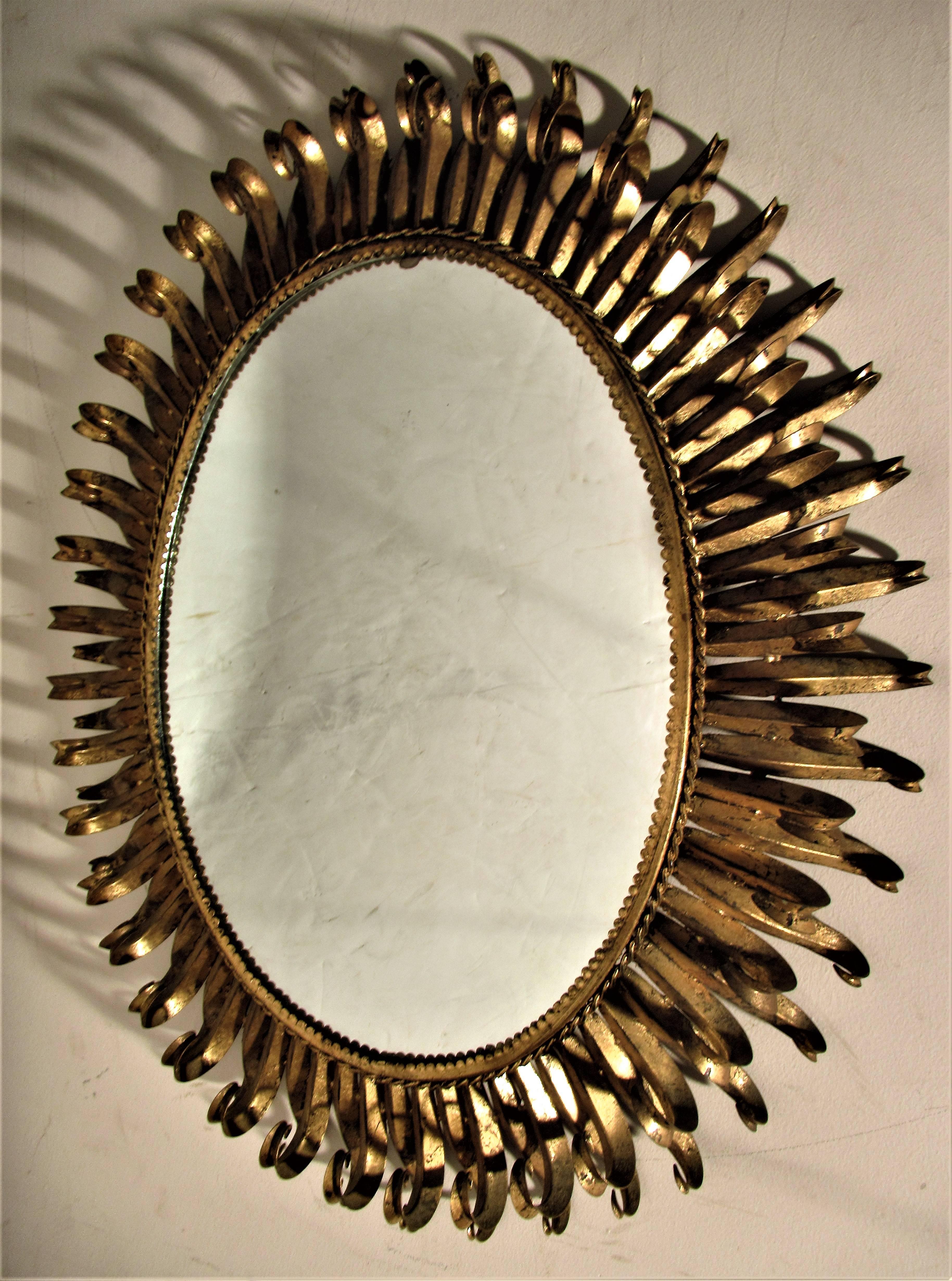 A larger than usual size oval gilt metal eyelash mirror in beautifully aged all original gilded surface. Spanish, circa 1960.