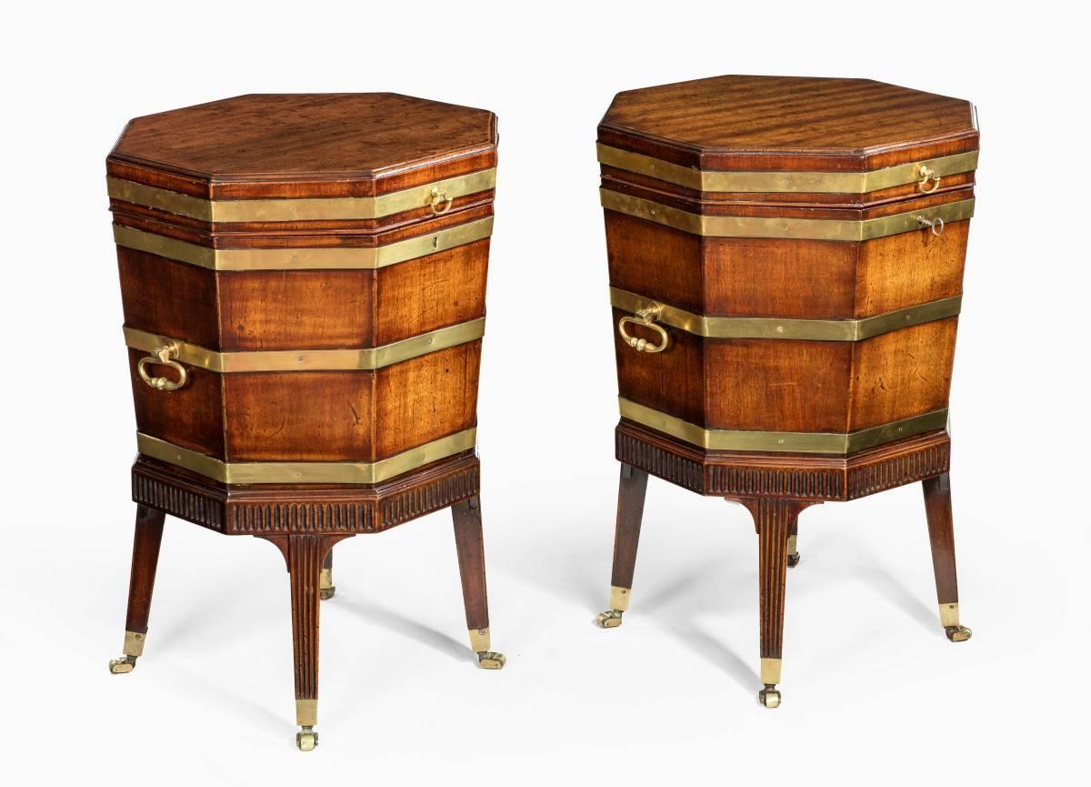 An outstanding pair of Georgian mahogany octagonal brass bound wine coolers/cellarets also know as gardes de vin. Which are recorded in George Hepplewhite's The Cabinet-Maker and Upholstery's 1st Edition 1788. 2nd Edition 1789. 3rd Edition 1794.