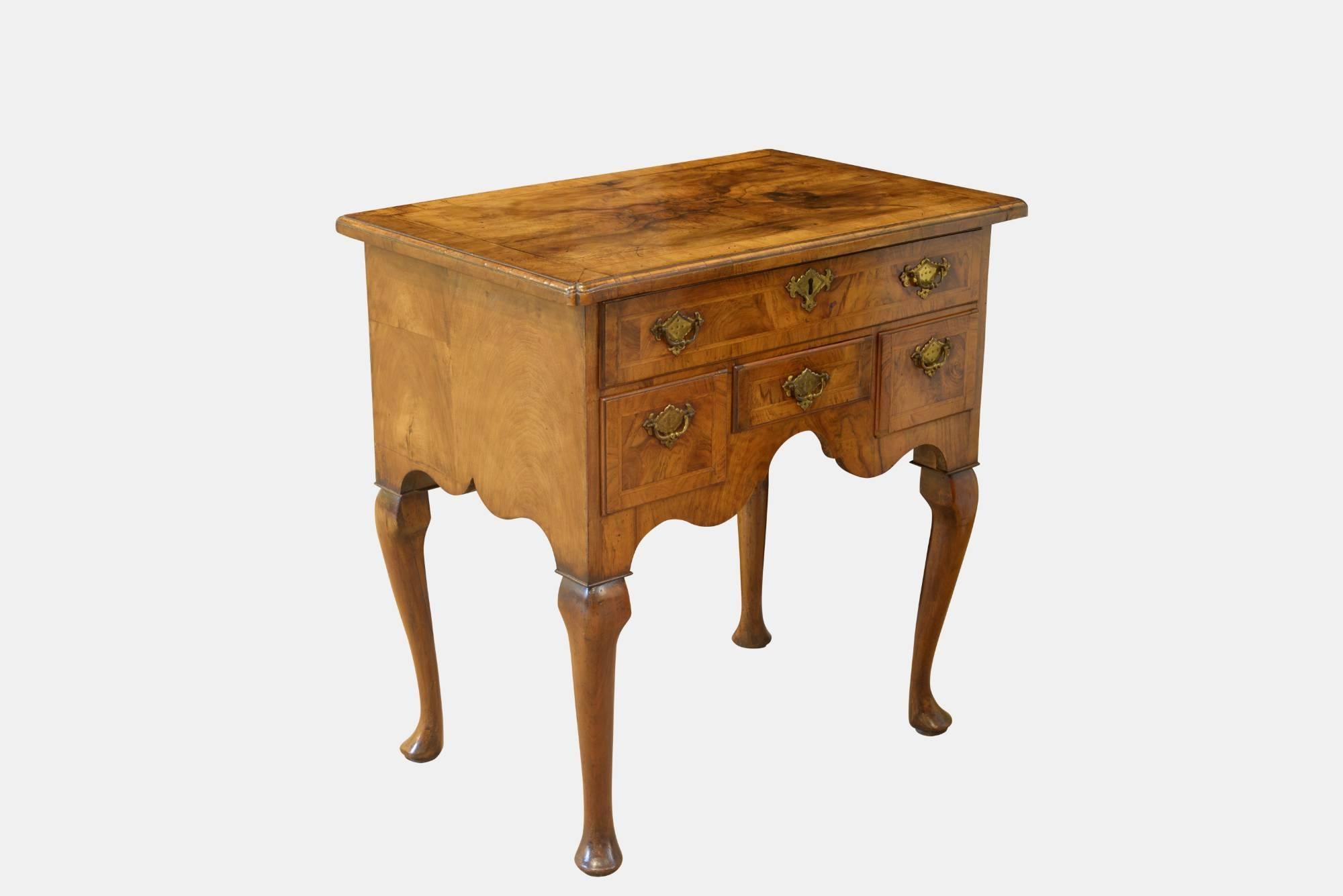 A fabulous George I walnut veneer lowboy of fine colour, the quartered feather and cross banded top with the re-entrant corners, one long and three short oak lined drawers retaining original brasses (some new wires). 19th Century lock by Cope &