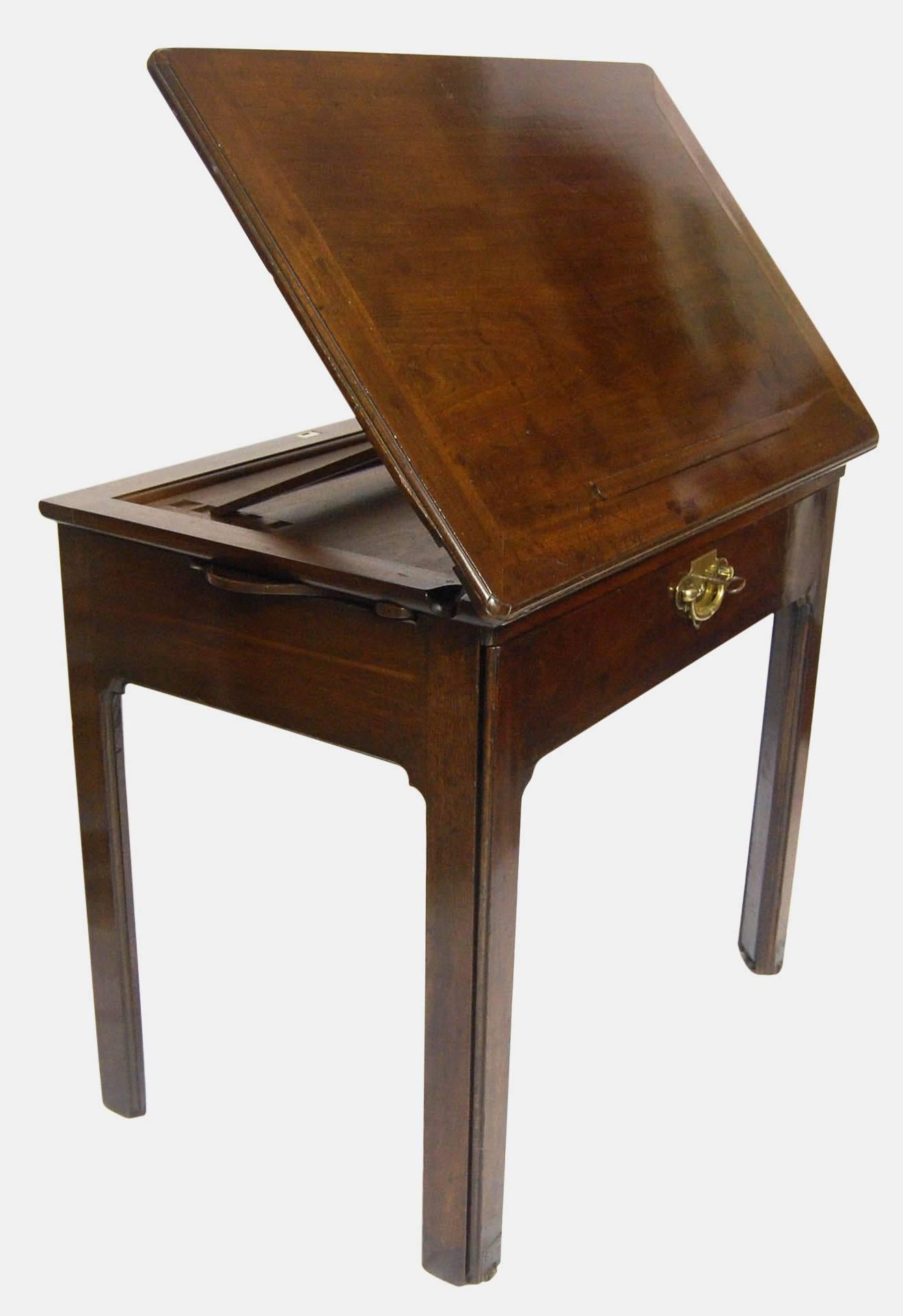 Georgian mahogany architects table with candle stands and drawers slides.

The top has a single ratchet to the base and book rest mechanism that extends from the front by means of two slides to the underside and retains it catch mechanism for