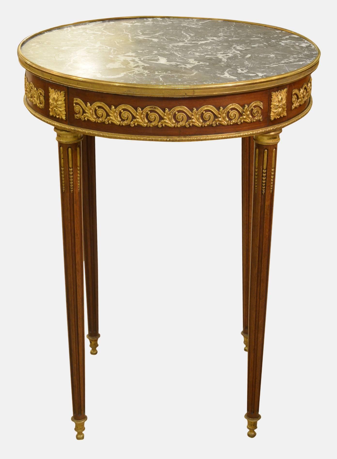 A Louis XVI style circular marble-topped Gueridon table with ormolu mounts to the fluted legs,

circa 1900.
Measures:
71.5cm (28.1