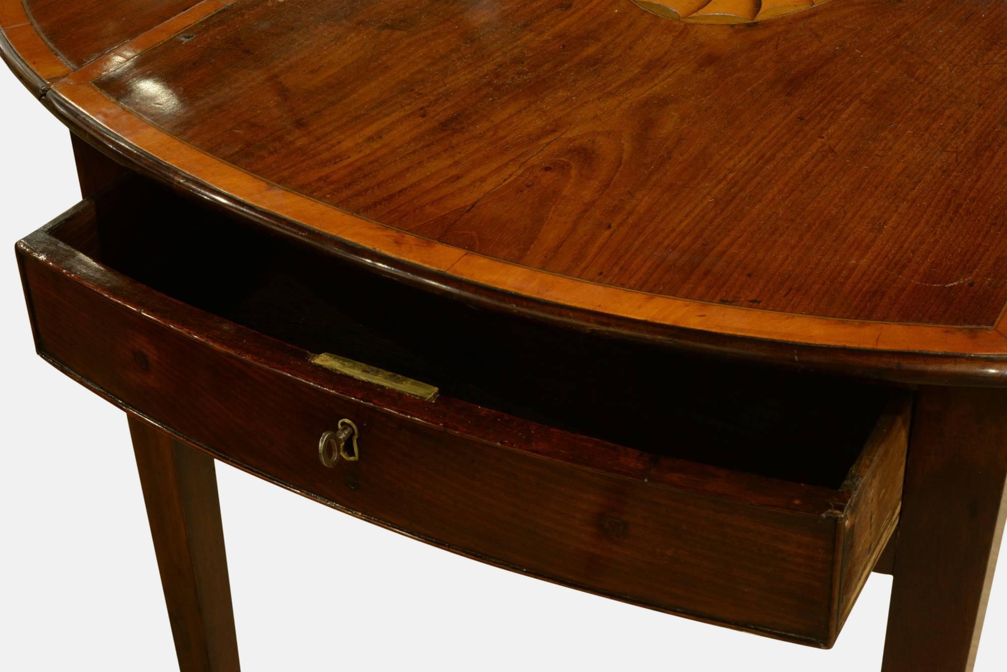 A George III mahogany satinwood banded and inlaid oval Pembroke table on square tapering legs. 
Dimensions: 67.5cm (26.6") - high.
90cm (28.3") - wide leaves up.
46cm - leaves down.
72cm depth.
               