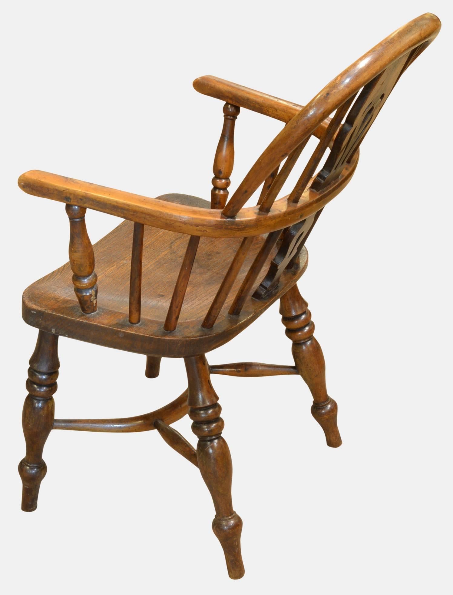 A good early 19th century child's yew-wood and elm seated, hoop back Windsor chair with crinoline stretcher,

circa 1830.