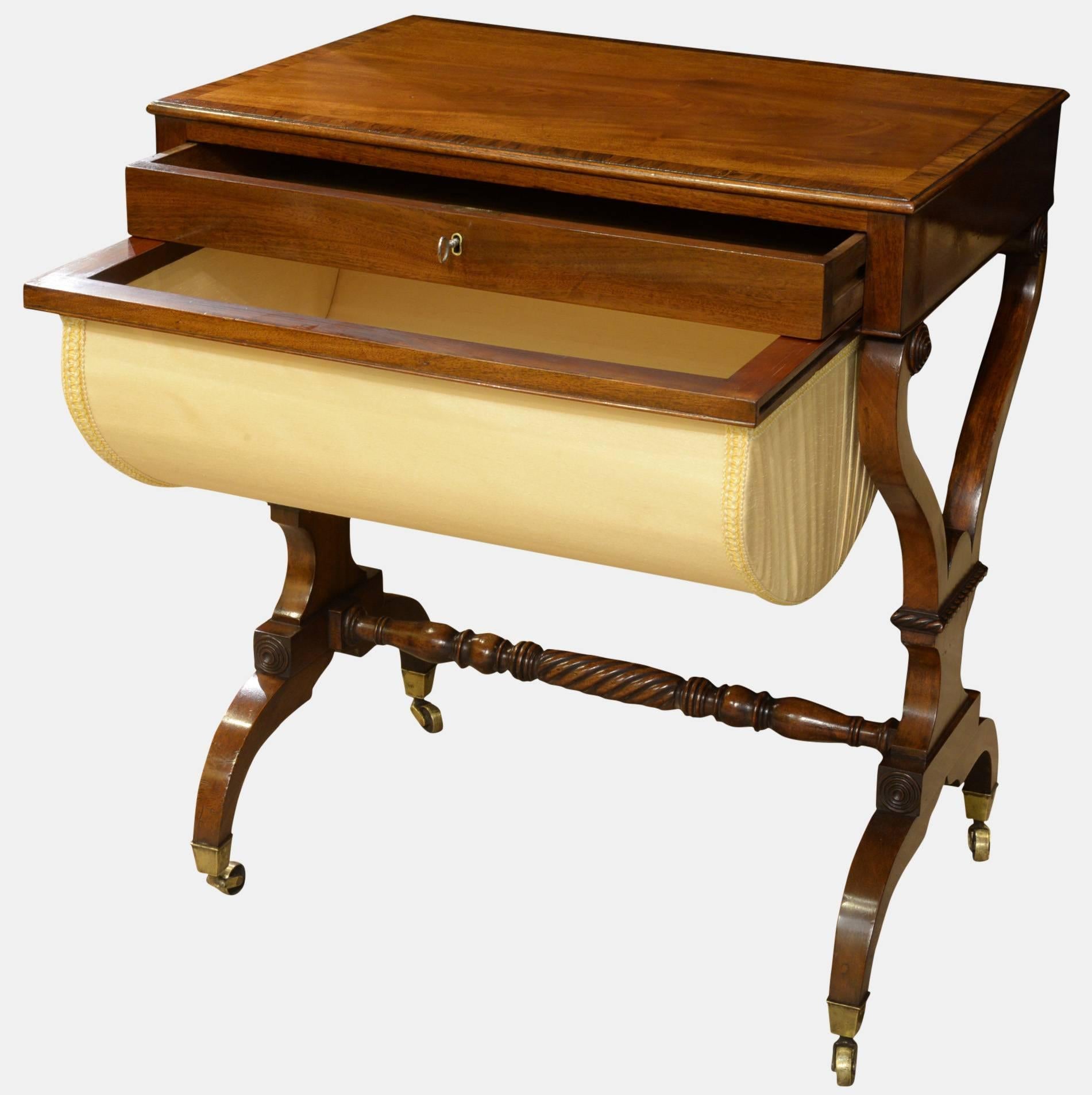 A fine English Regency mahogany sewing table, crossbanded in rosewood. Single drawer over a sliding work box, raised on lyre end supports. Rope twist carved detail.

circa 1810.
 