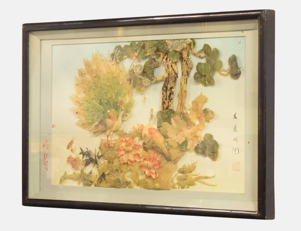 20th century Chinese mother-of-pearl and hardstone picture worked in high relief with a peacock amongst flowers and trees.