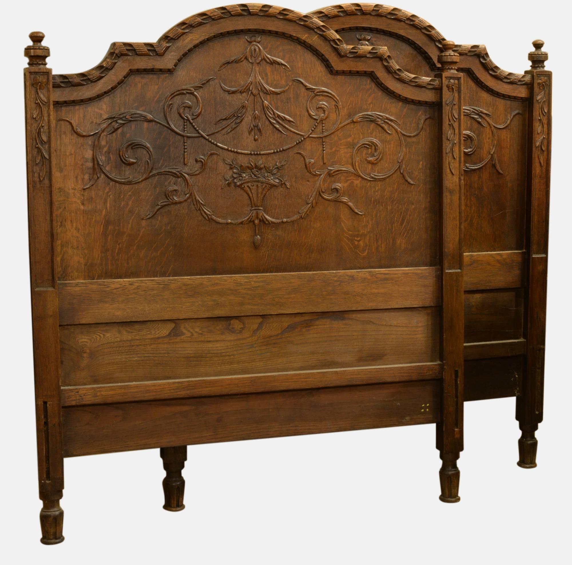 A pair of French carved oak single beds in Provencale style.